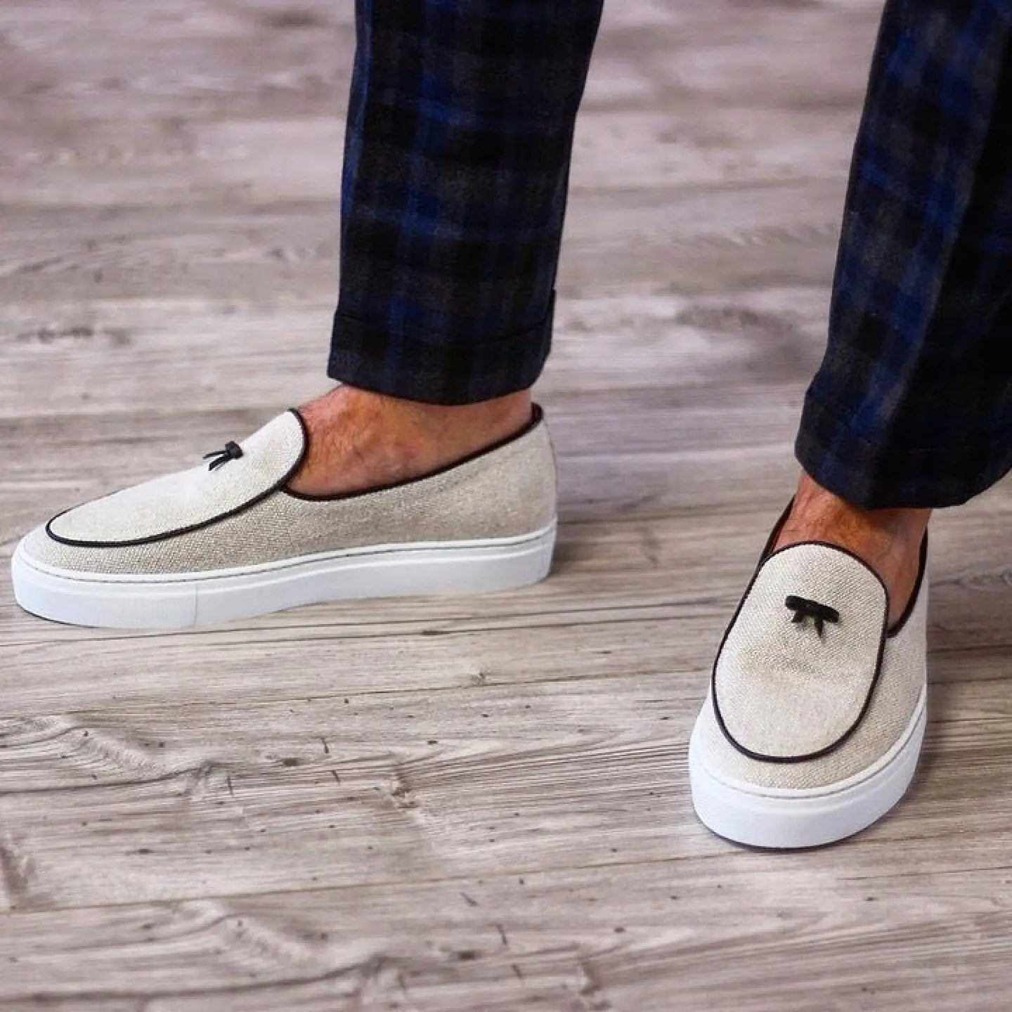 Beige slip-on shoes with black trim.