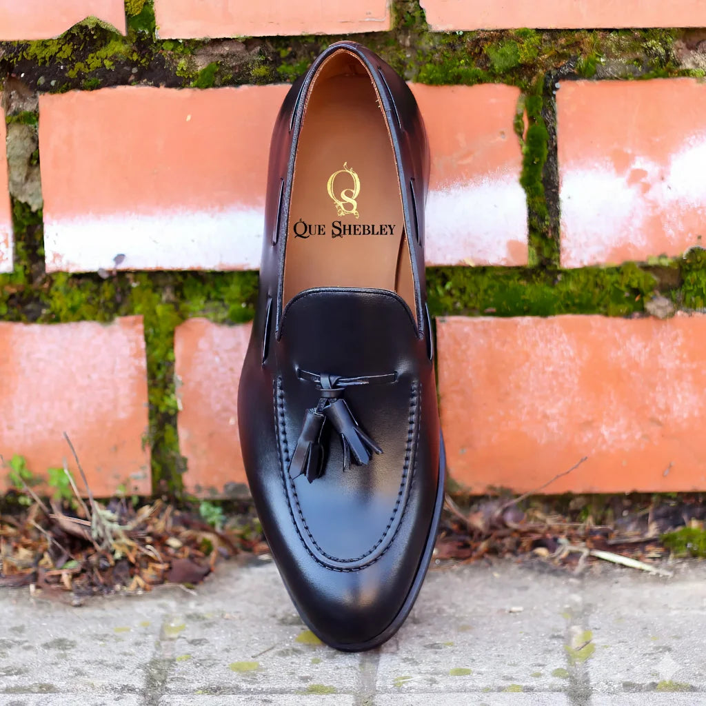 1901 Loafers: black leather tassel with Que Shelley branding