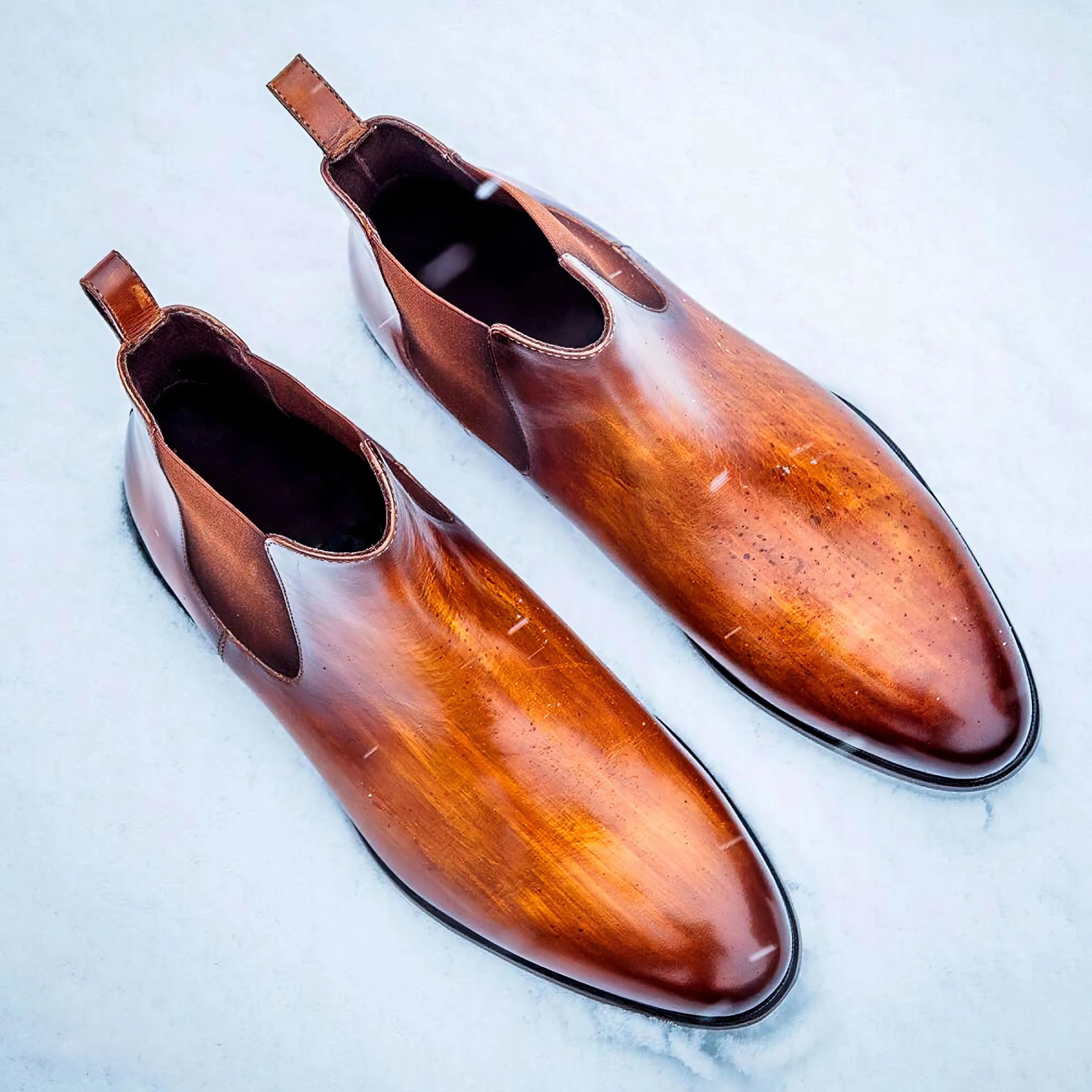 Pair of brown leather Patina Chelsea Boots showcasing elegant craftsmanship and design