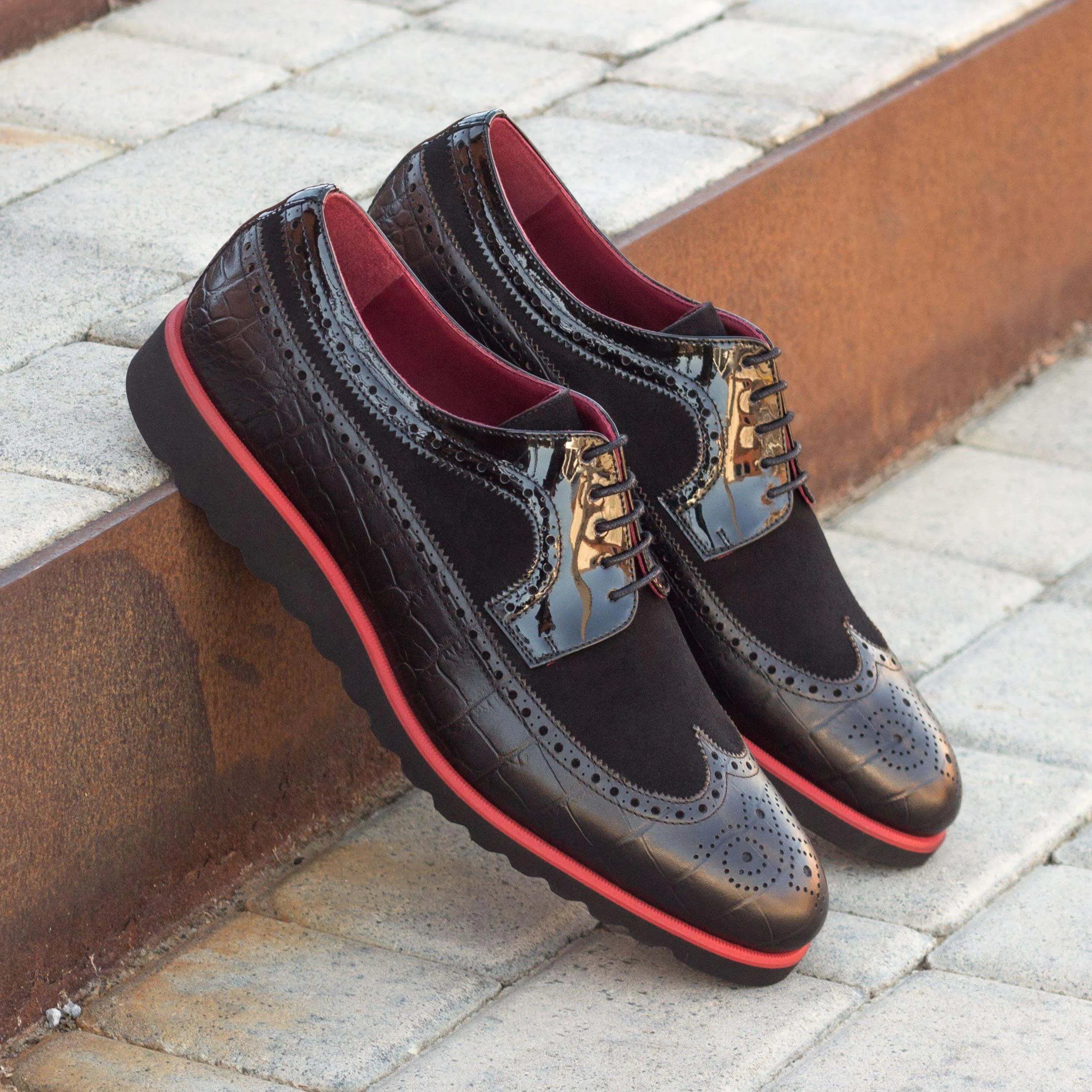 Pair of black patent leather wingtips, showcasing Abebe Longwing Blucher II style