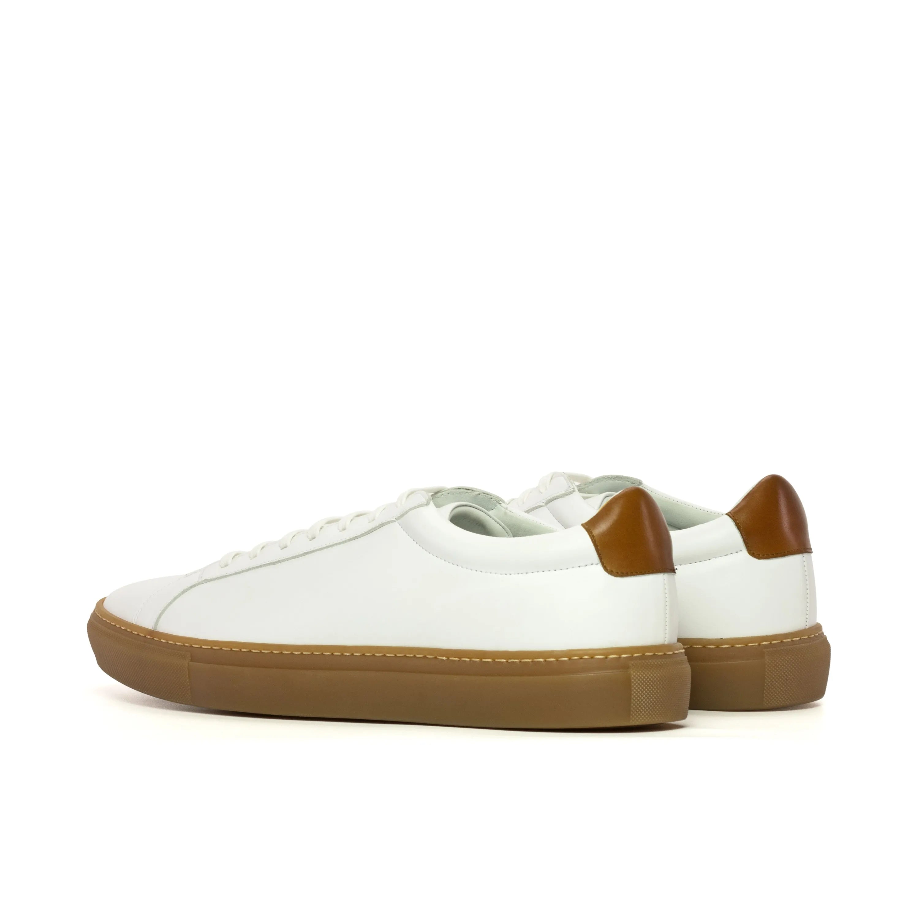White leather Conquest low kick sneakers with stylish brown soles for modern footwear