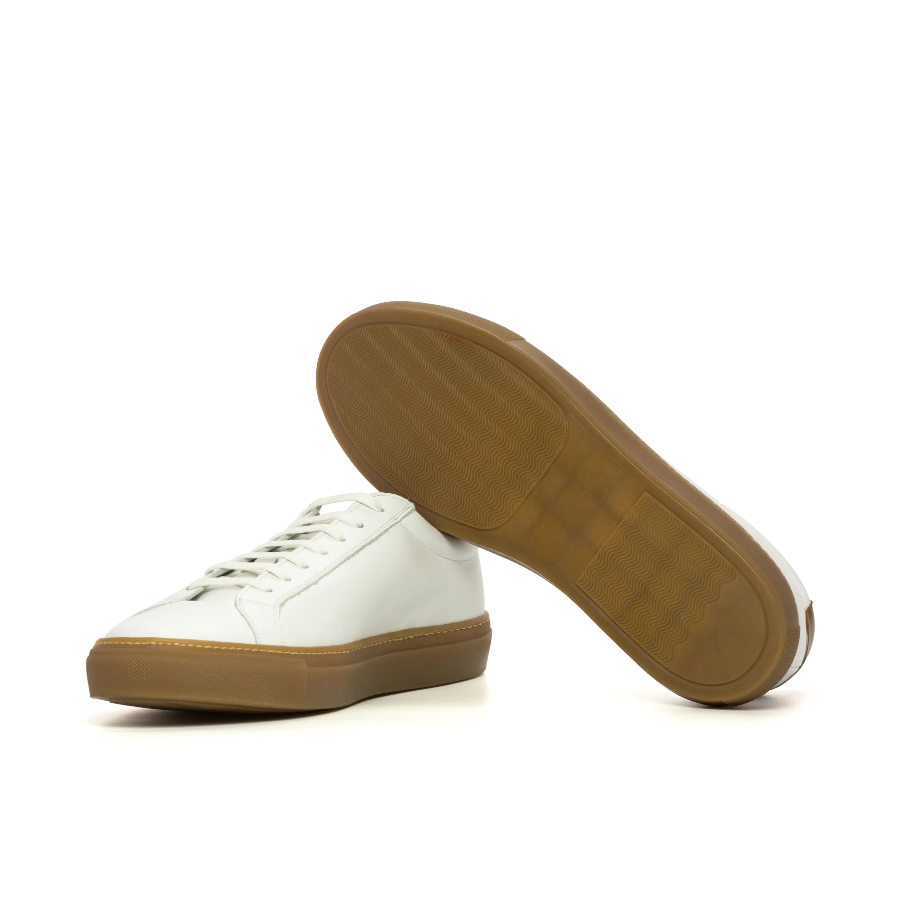 White leather Conquest low kick sneakers with brown soles for stylish comfort