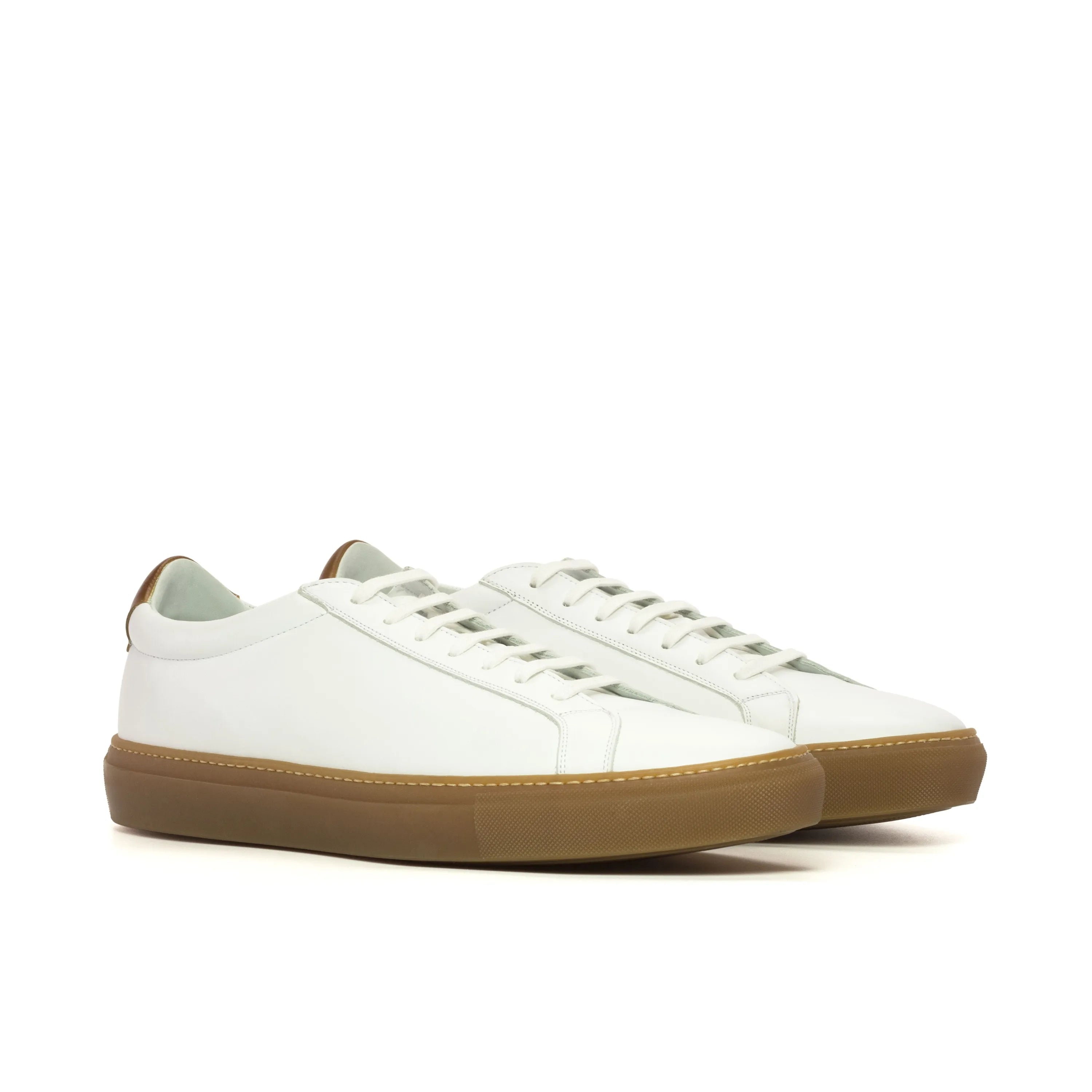 White leather Conquest low kick sneakers with brown soles for stylish comfort