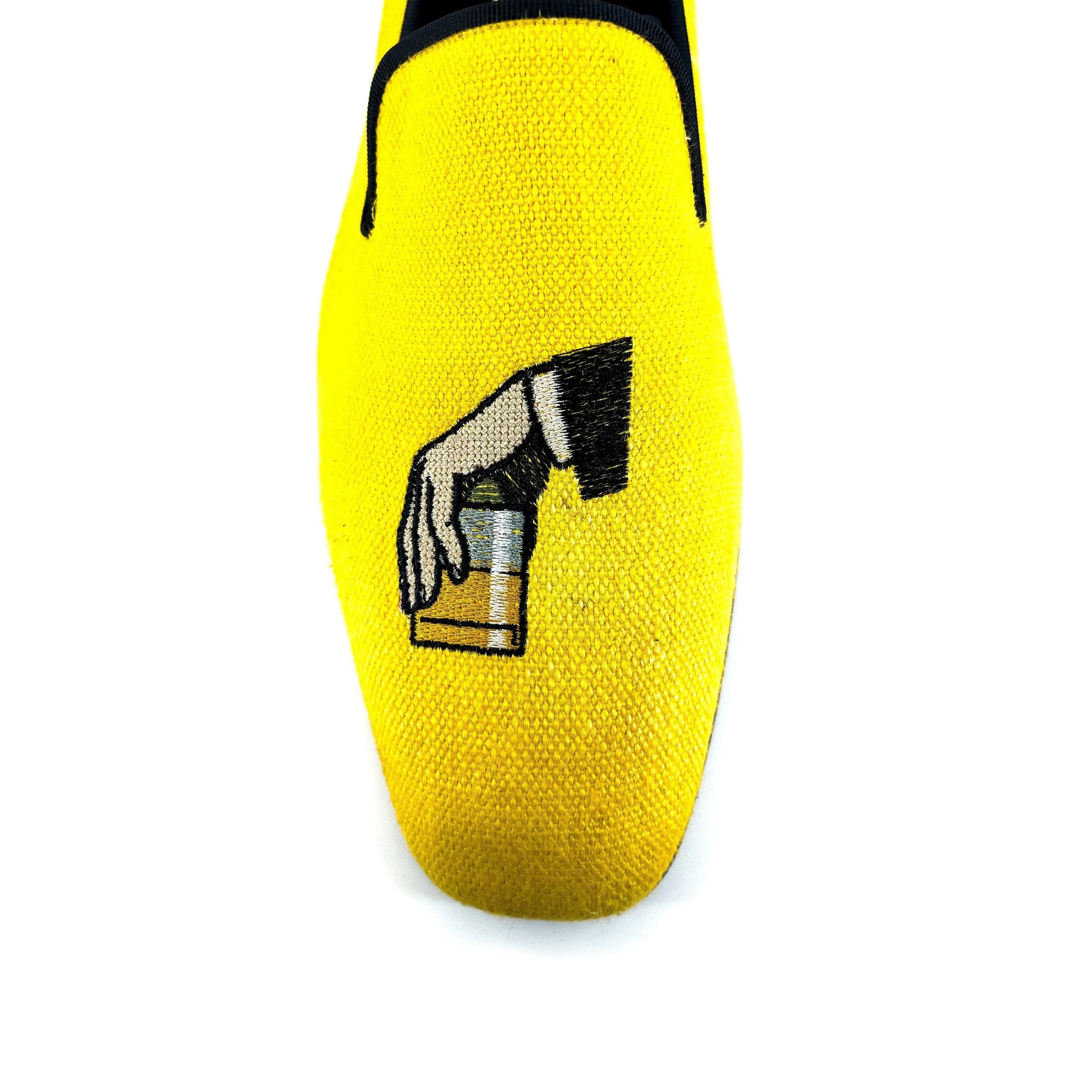 Yellow Don Drake slipon loafer with embroidered hand holding a drink