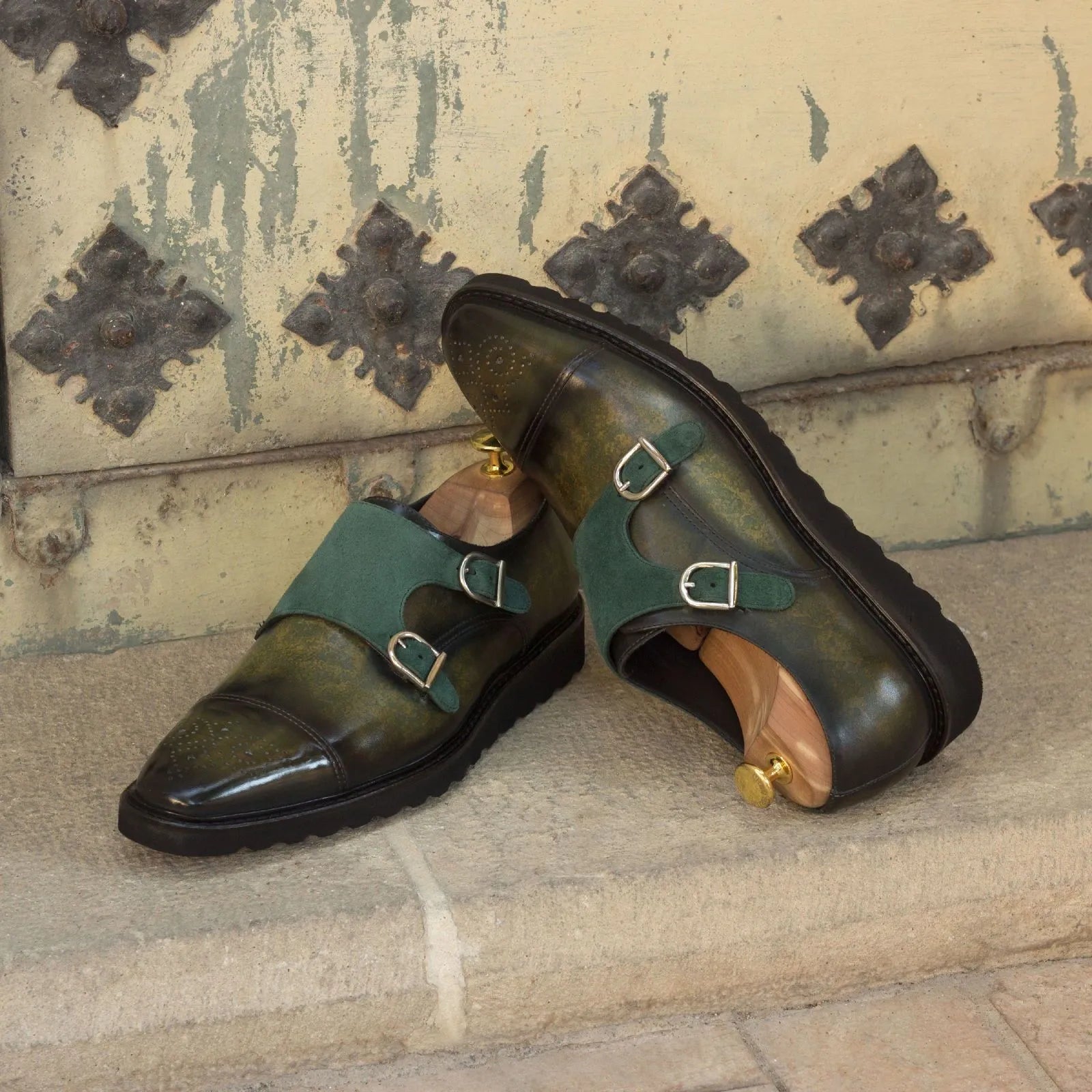 Green leather Dunstan Patina Double Monk strap shoes displayed elegantly