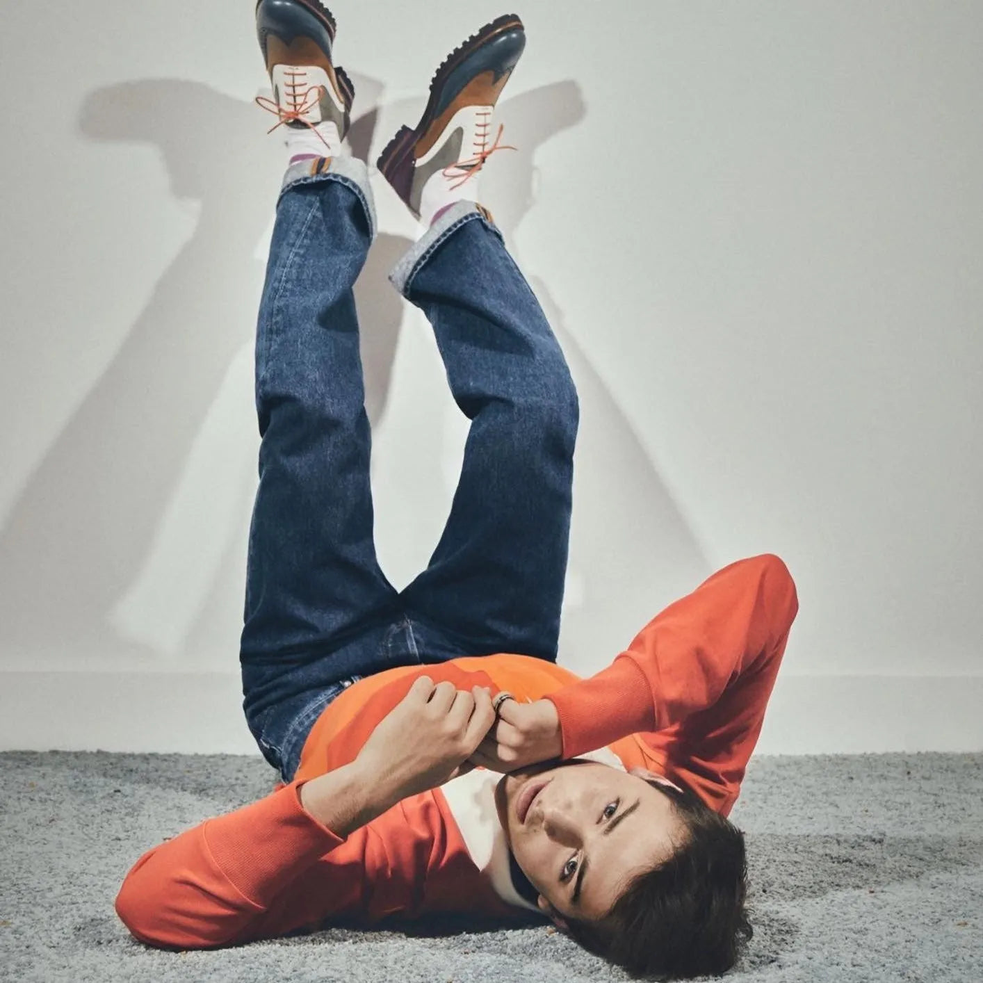 Person lying upside down wearing Eleanor unisex brogue shoes made of painted calf