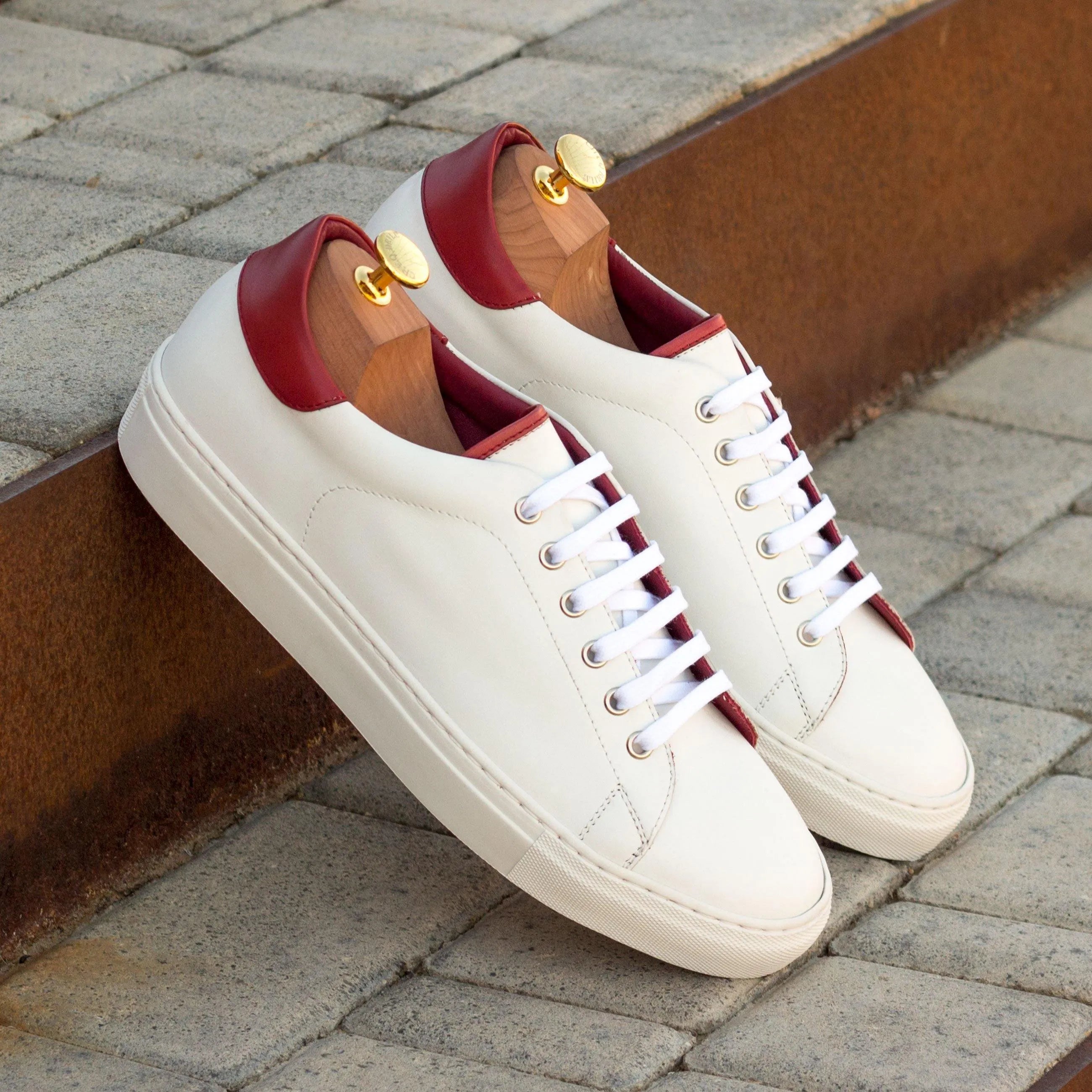 White leather Fridays Trainer Sneakers featuring red accents and a stylish cupsole design