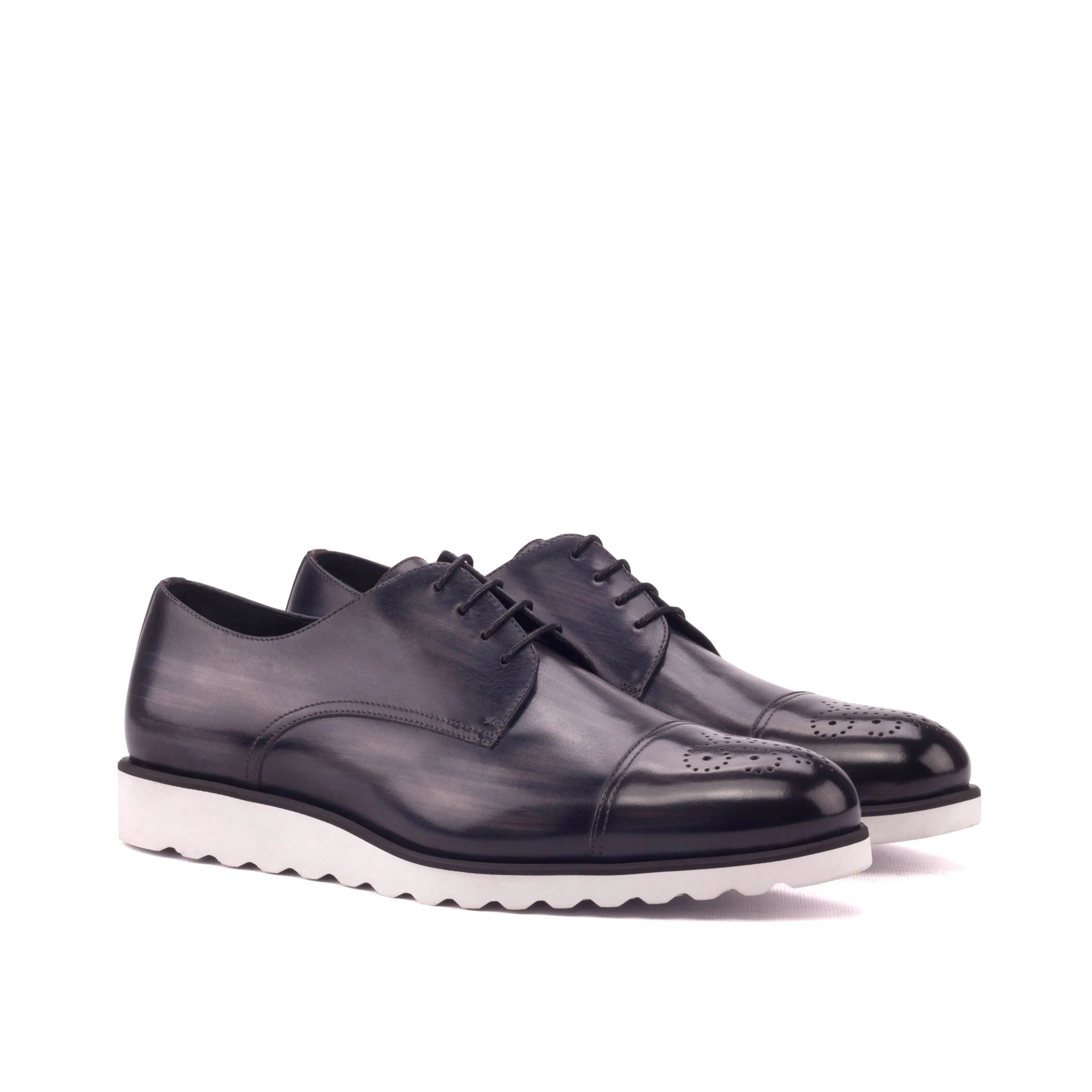 Pair of Griffith Patina Derby shoes featuring black leather with white soles