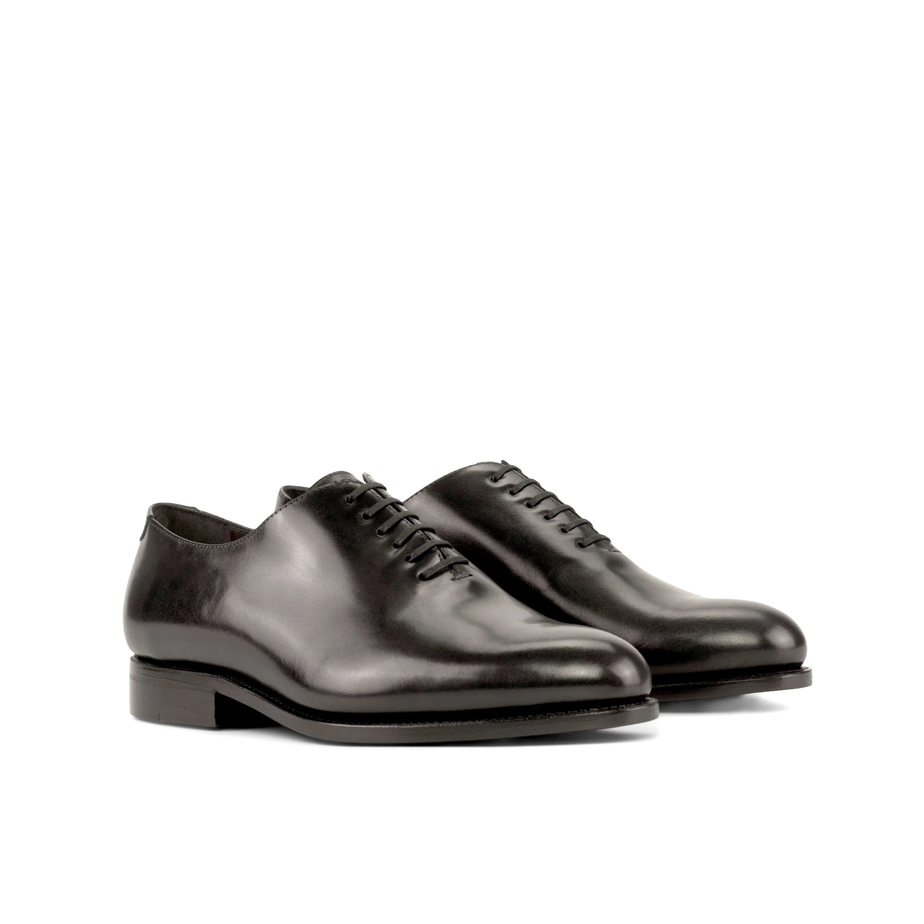 Pair of black leather Hans Wholecut shoes showcasing elegant craftsmanship and style