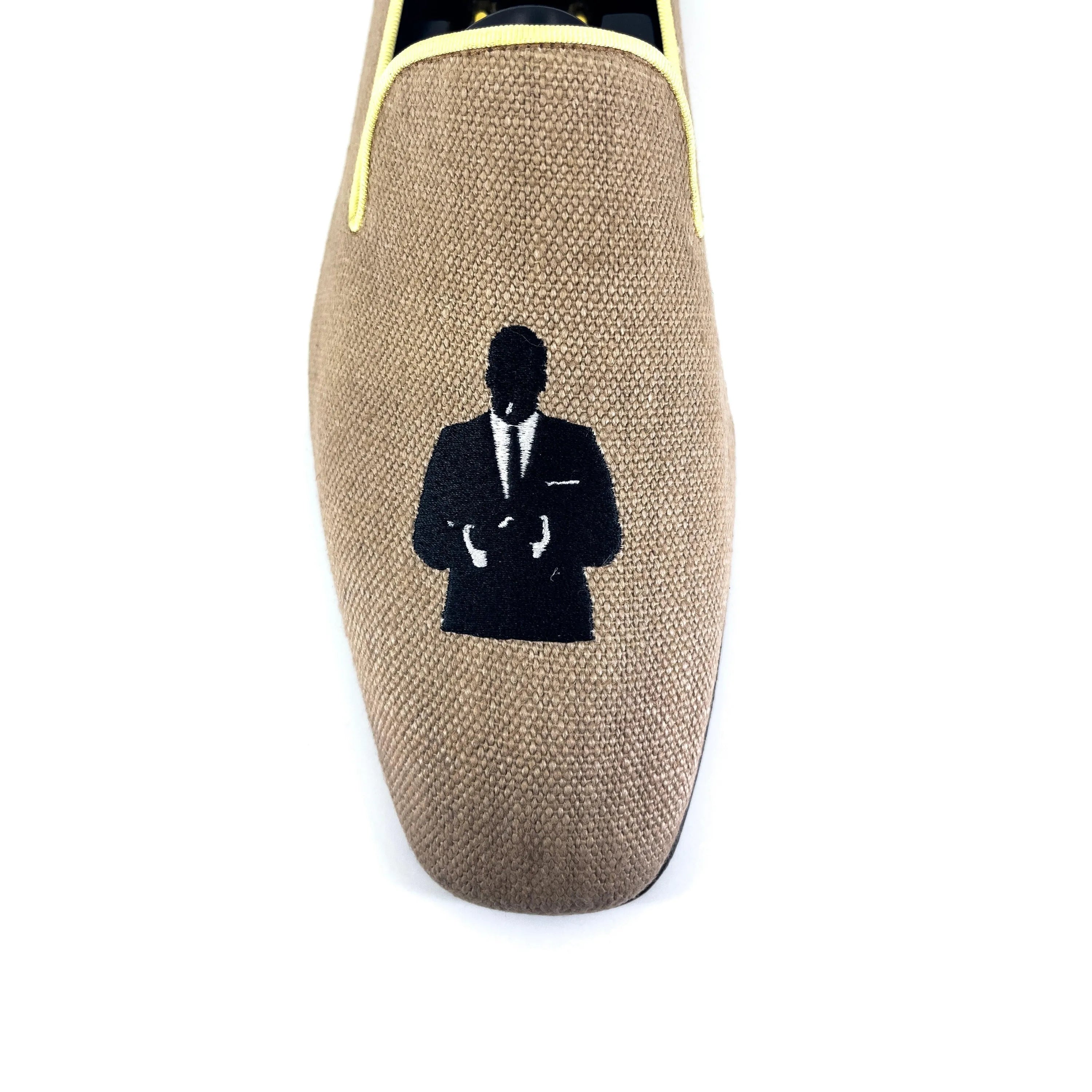 Tan Lane Drake Slipon loafer displayed alongside a silhouette of a man in a suit