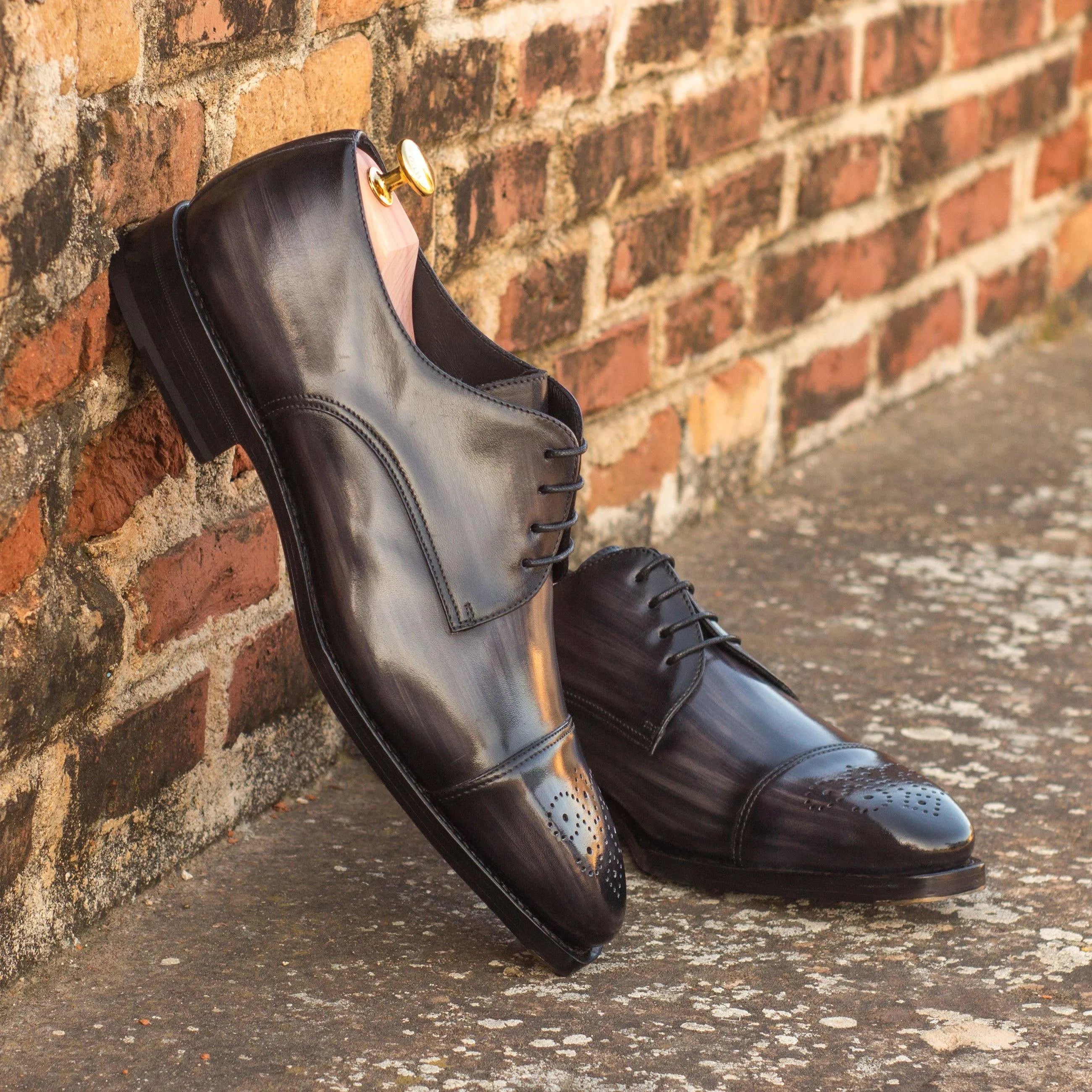 Pair of black leather dress shoes featuring Marion Patina Derby design and derby split toe