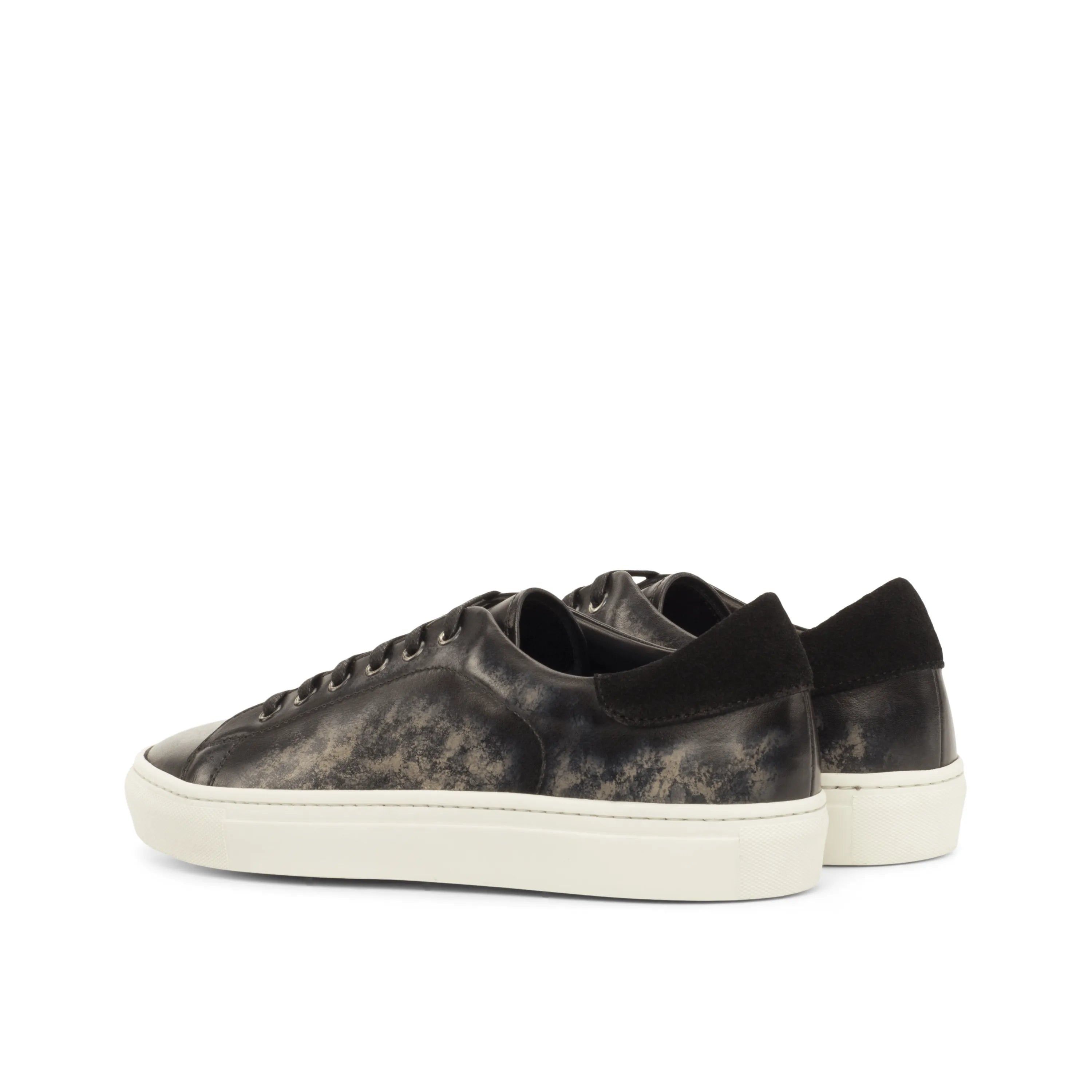 Black leather Nira Trainer Patina Sneakers featuring stylish white soles and modern design