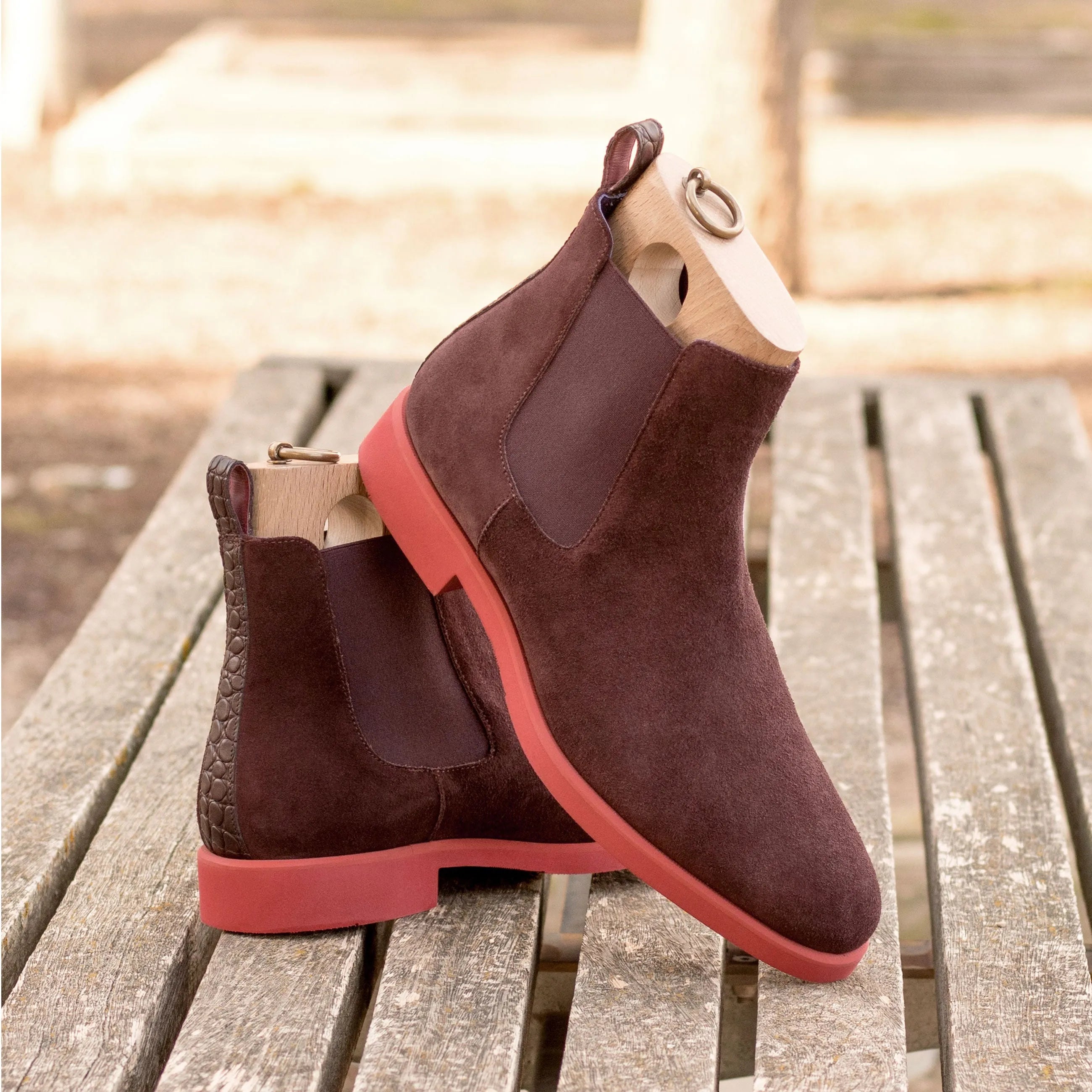 Brown suede Poppy Chelsea boot with striking red soles, stylish and versatile footwear