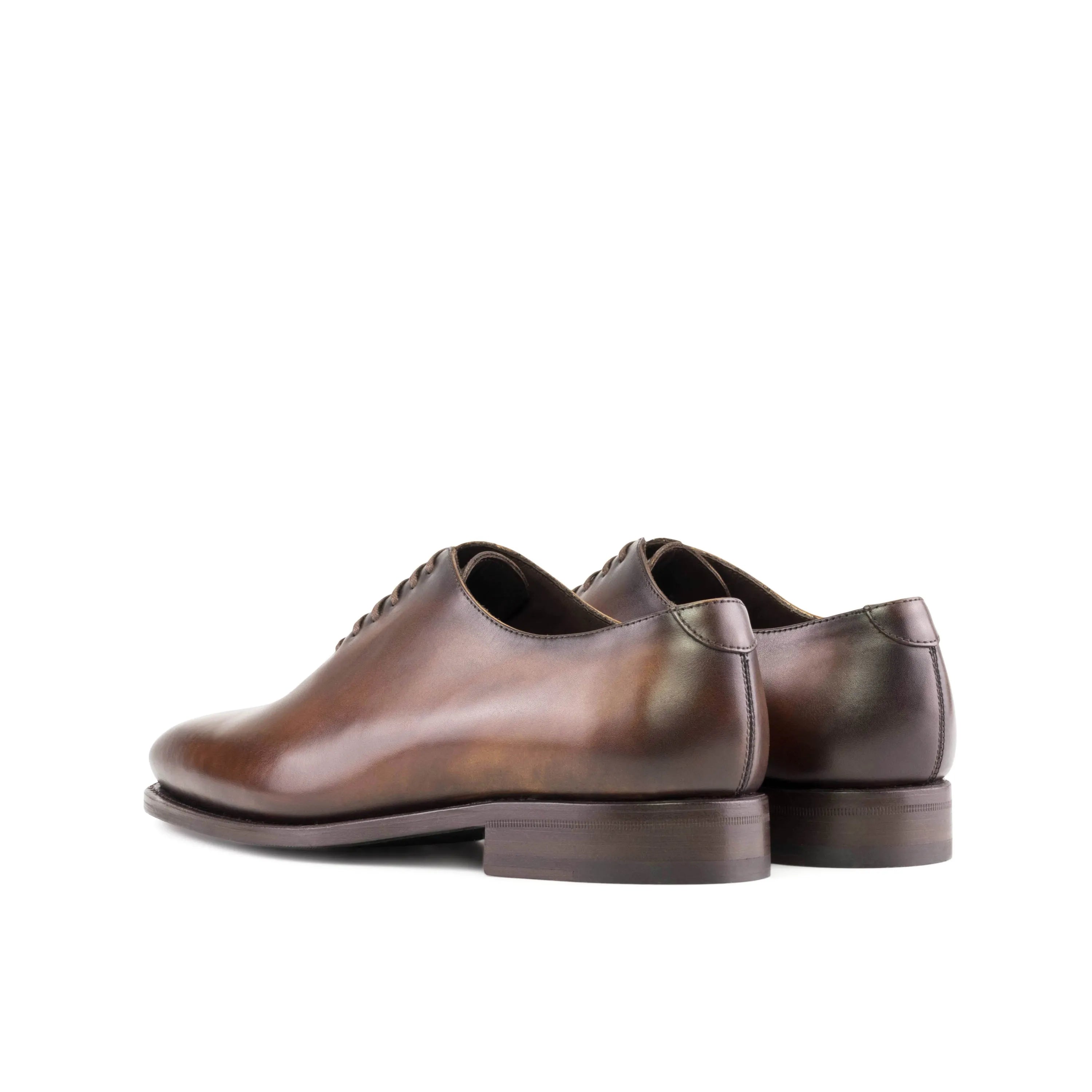 Pair of brown leather Renzo Wholecut shoes showcasing classic elegance and craftsmanship