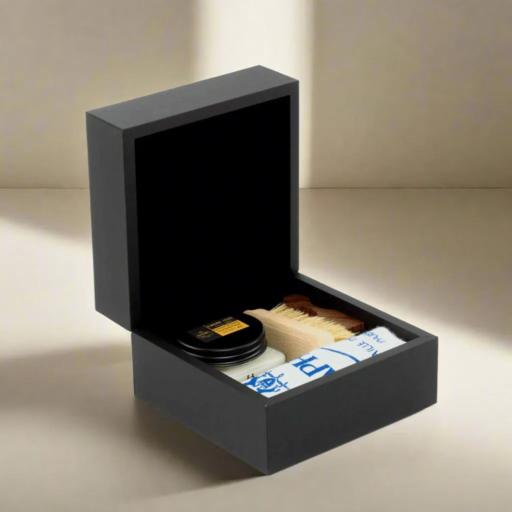 Open black shoe-shine box showcasing Saphir Premium Leather Care Kit and Medaille d’Or products