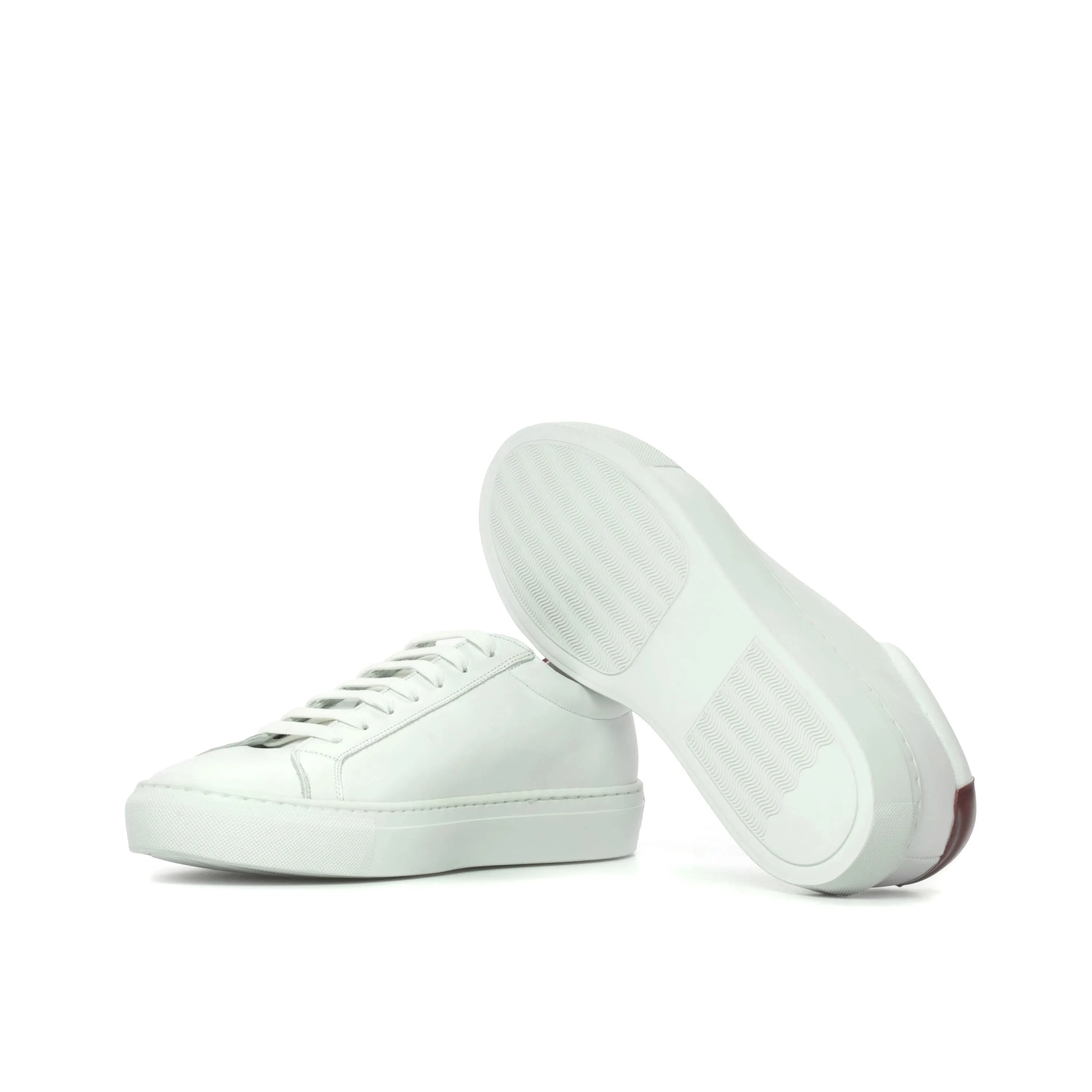 Pair of white leather Sima Low Kick Sneakers ideal for a fast lane lifestyle