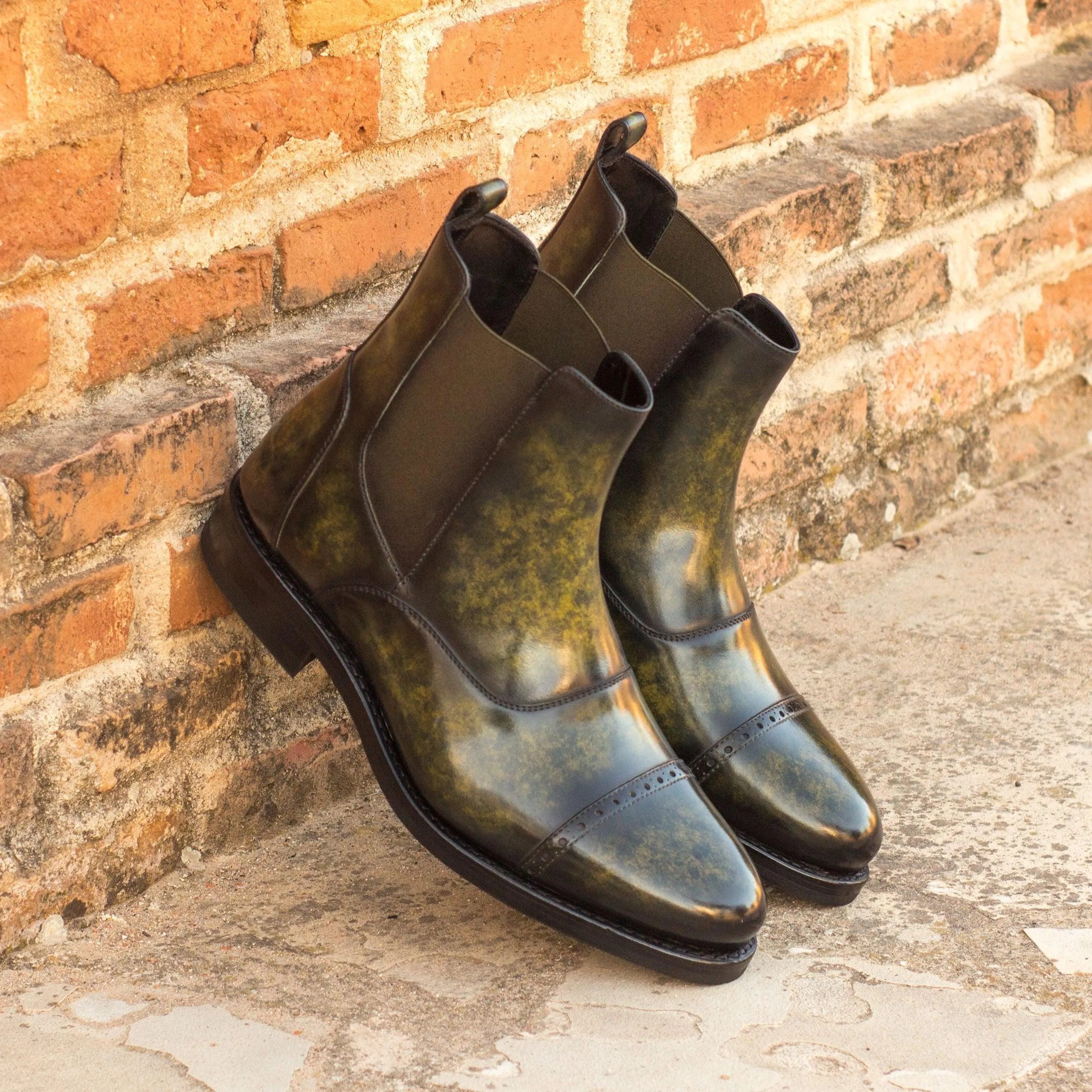 Pair of green leather Wardon Patina Chelsea Boots II showcasing elegant design and style