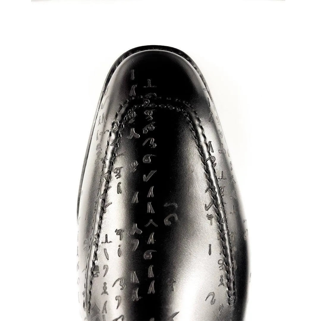 Black leather dress shoe with embossed symbols.