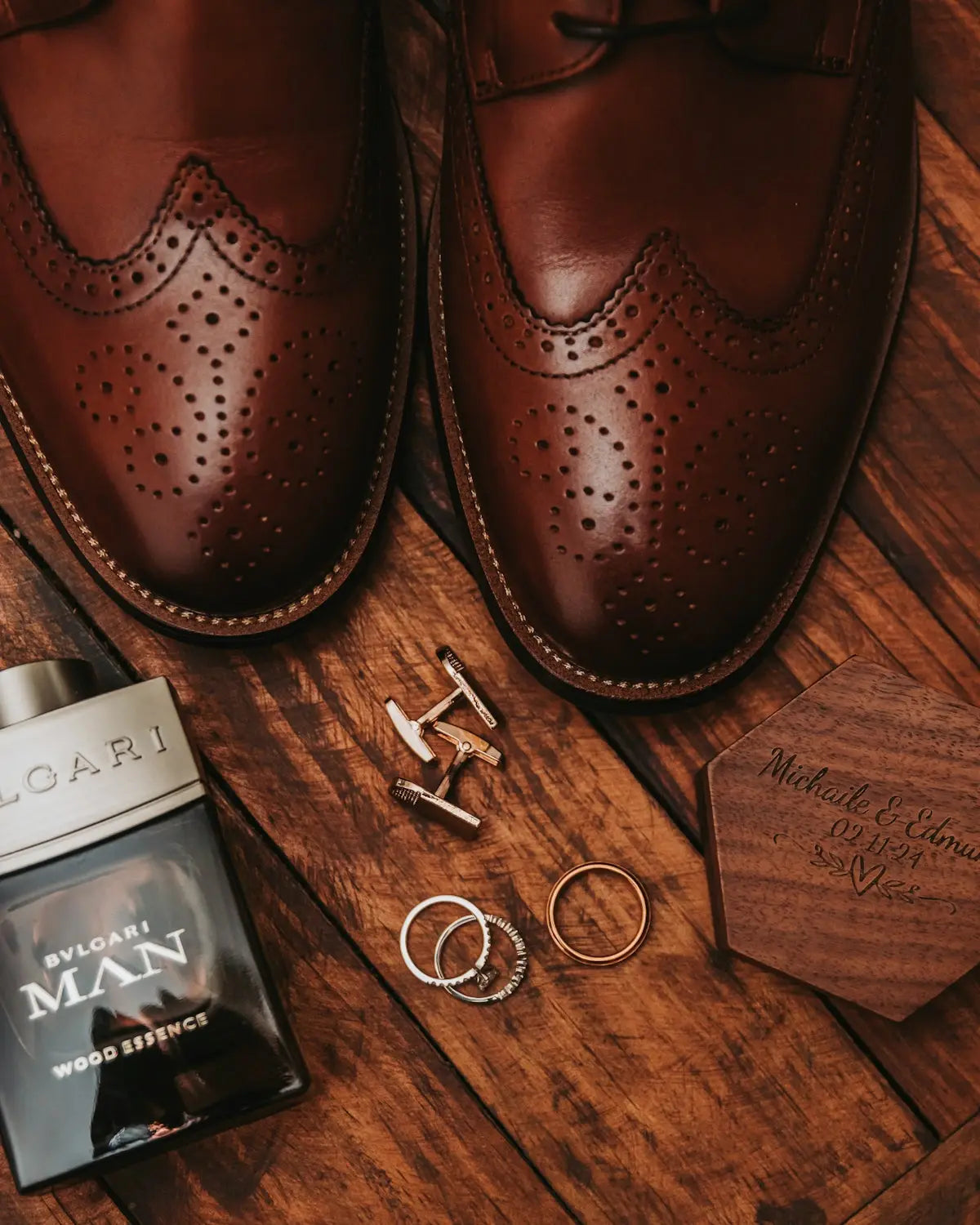 A pair of brown shoes next to a pair of silver rings