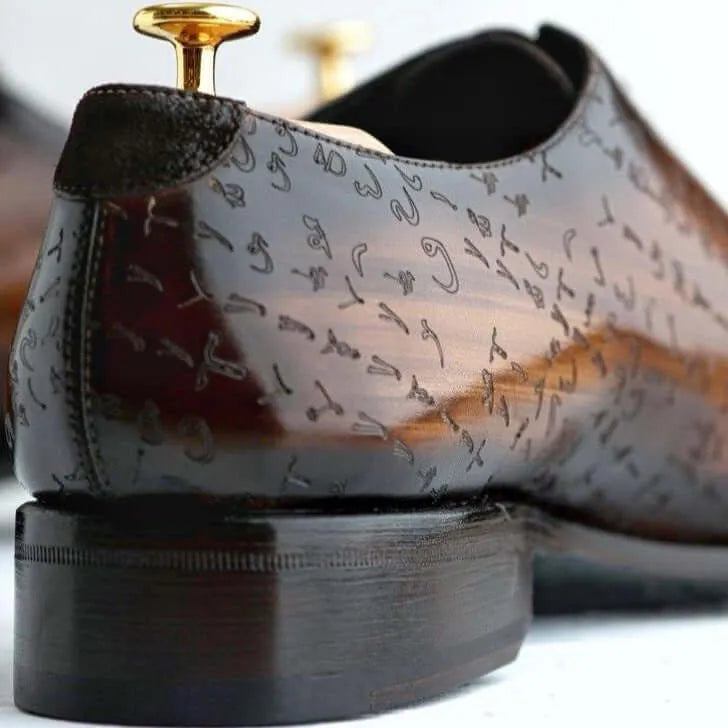 Brown leather dress shoe with decorative markings.