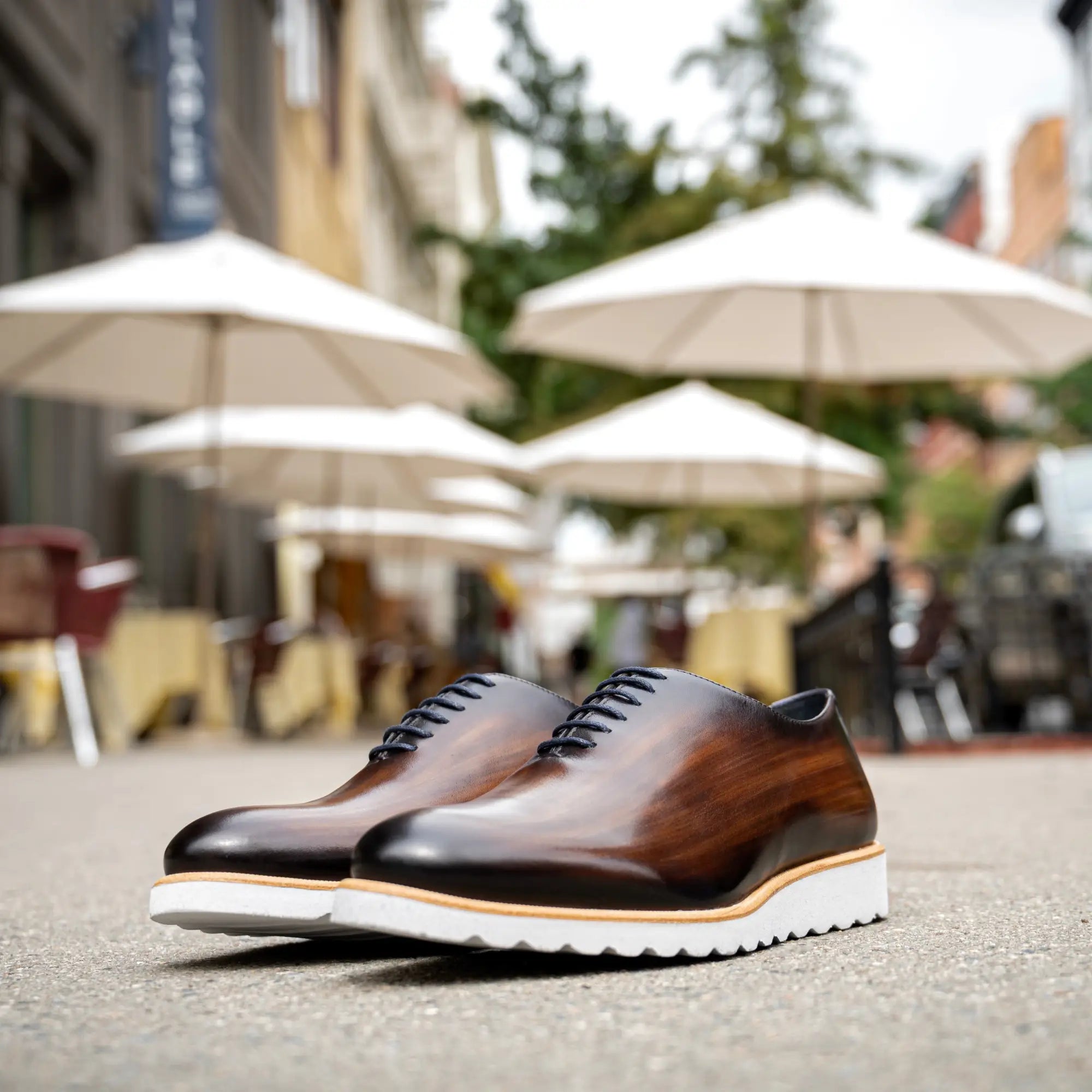 Brown leather dress shoes with white soles.