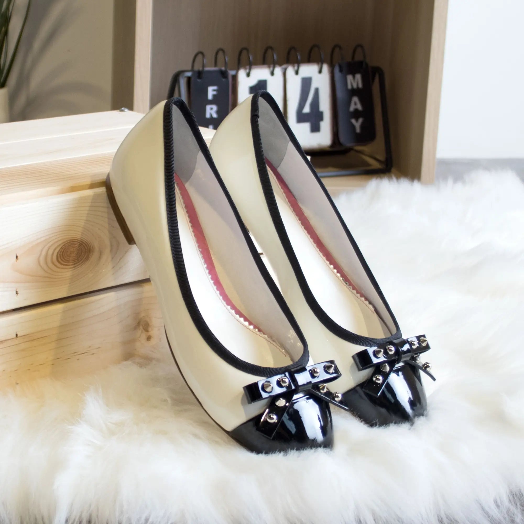Beige and black patent leather flats.