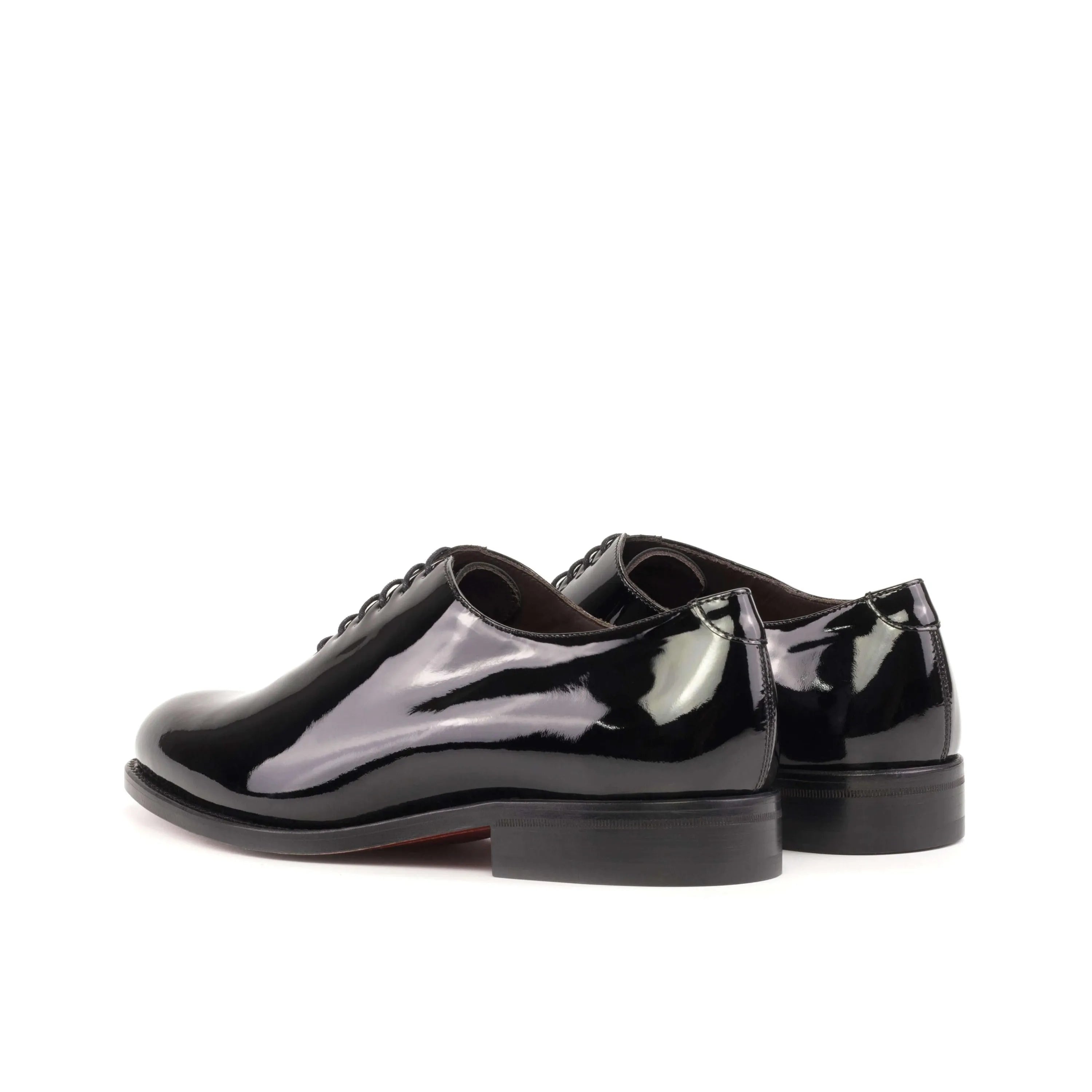 Pair of shiny black Agent Wholecut shoes showcasing elegant craftsmanship and style