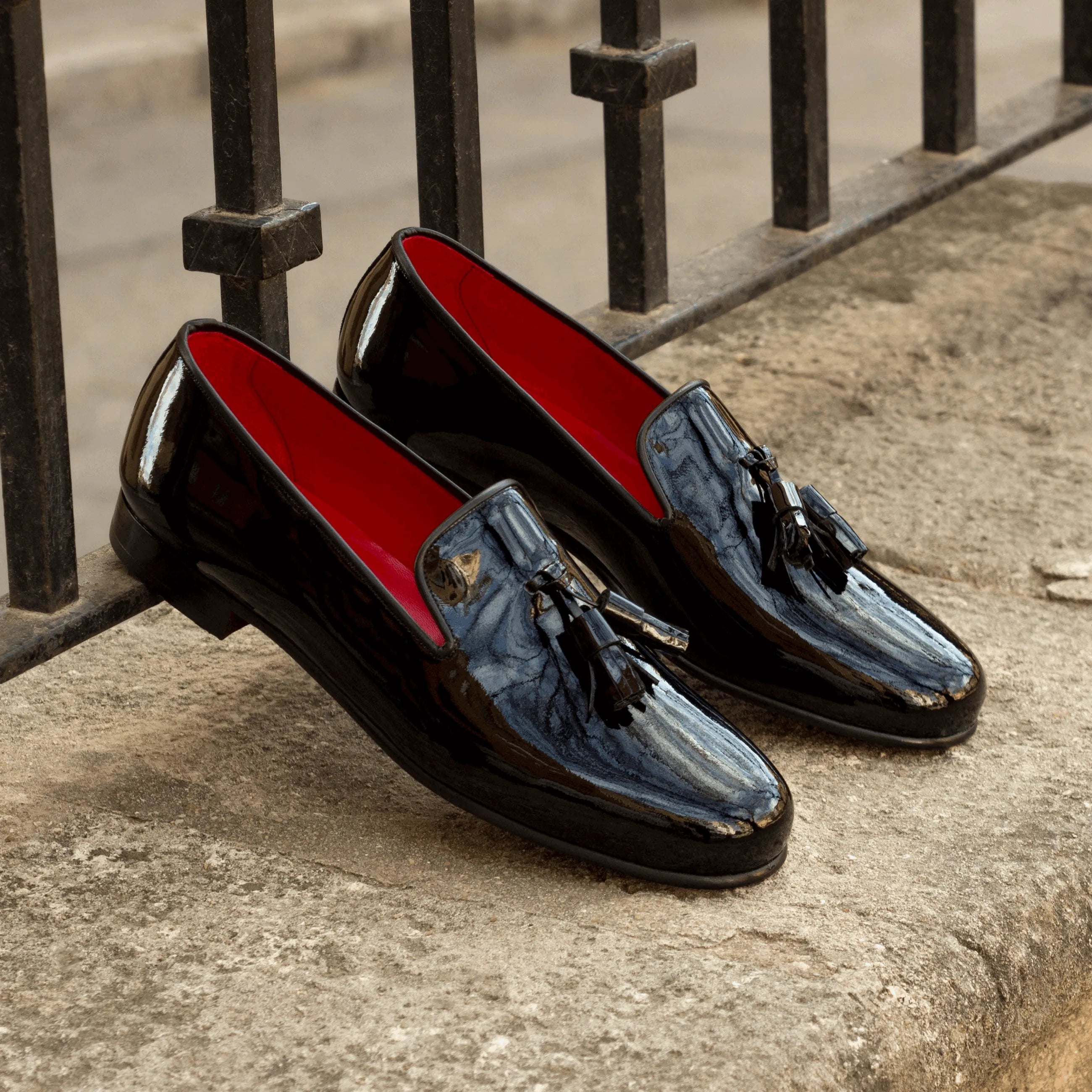 Pair of shiny black tassel loafers featuring the Amuso Wellington slip on design