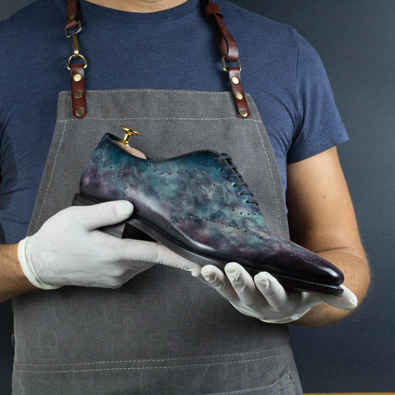 Hand-held blue and purple leather Cygnus Patina Wholecut dress shoe showcased elegantly