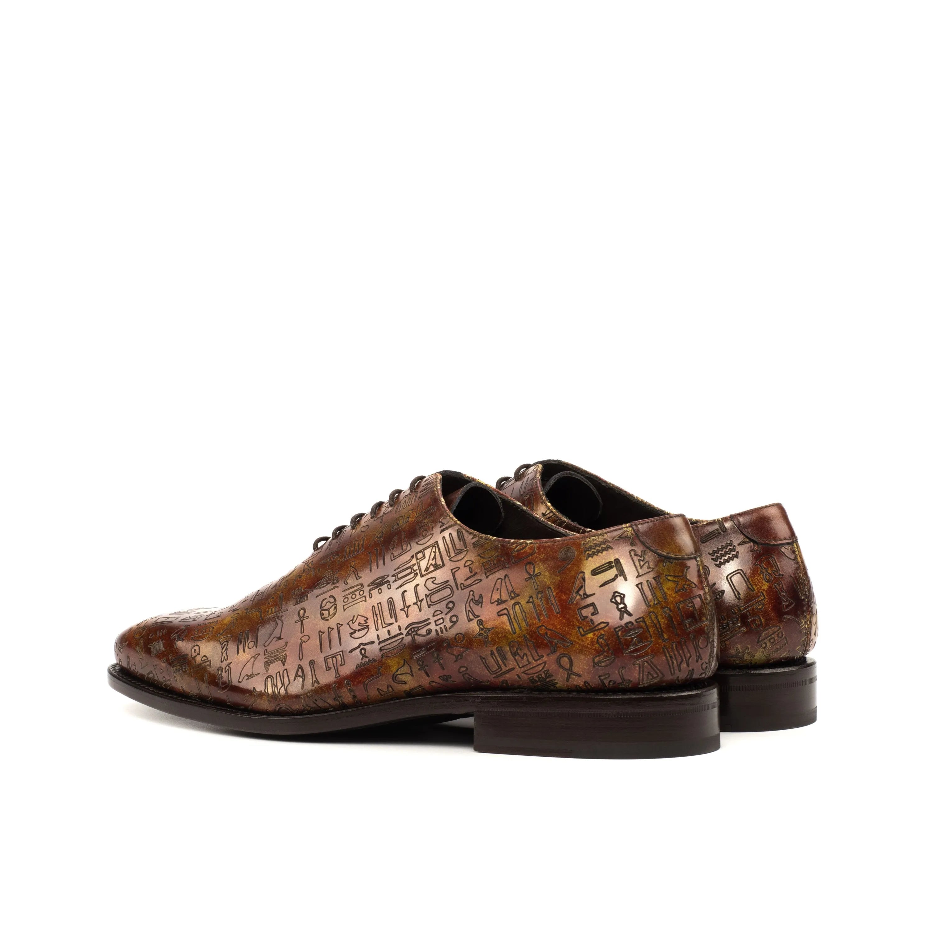 Brown leather Egyptian Patina Wholecut shoes featuring hieroglyphic pattern and soft chisel toe