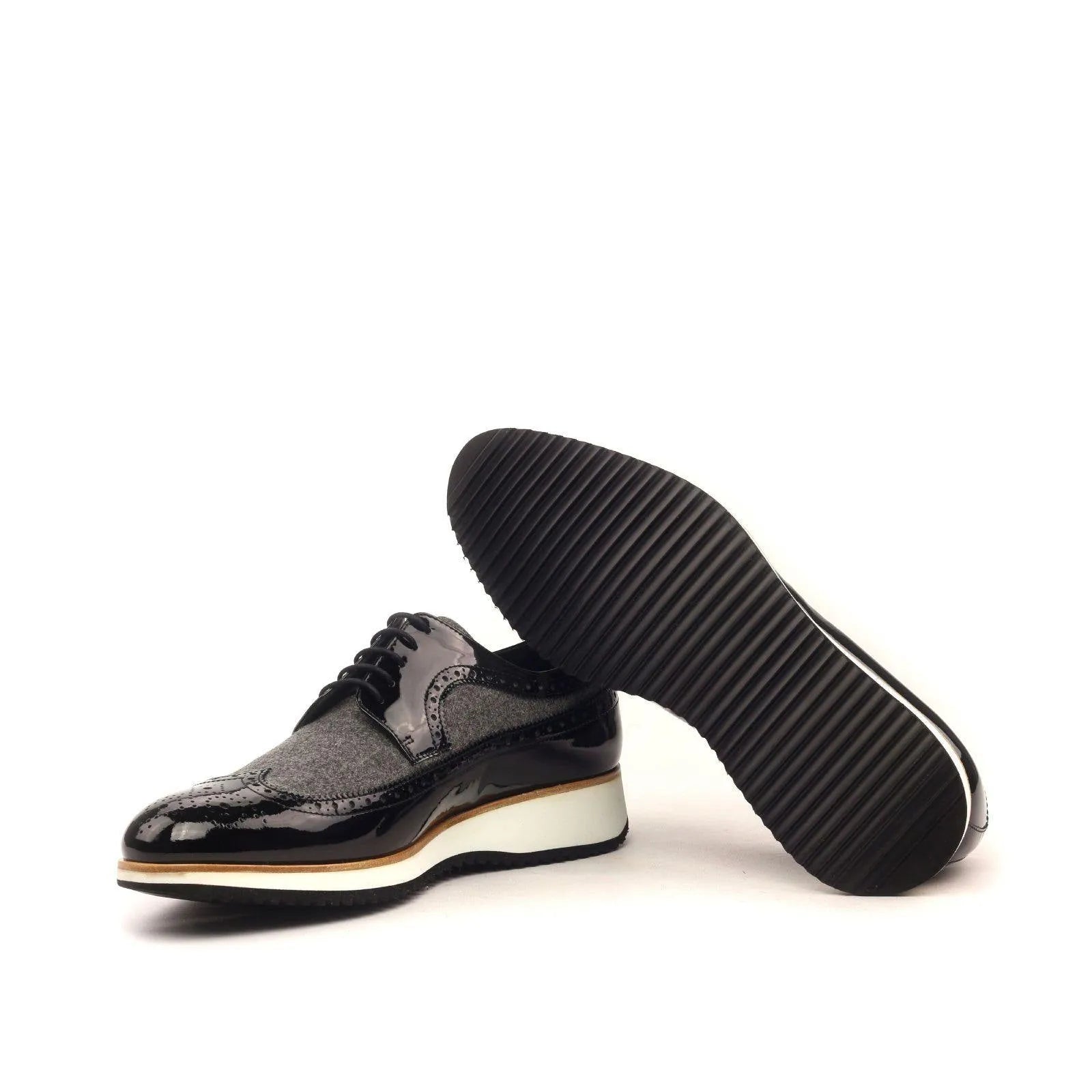 Black patent leather dress shoes, featuring the J Milton Longwing Blucher design
