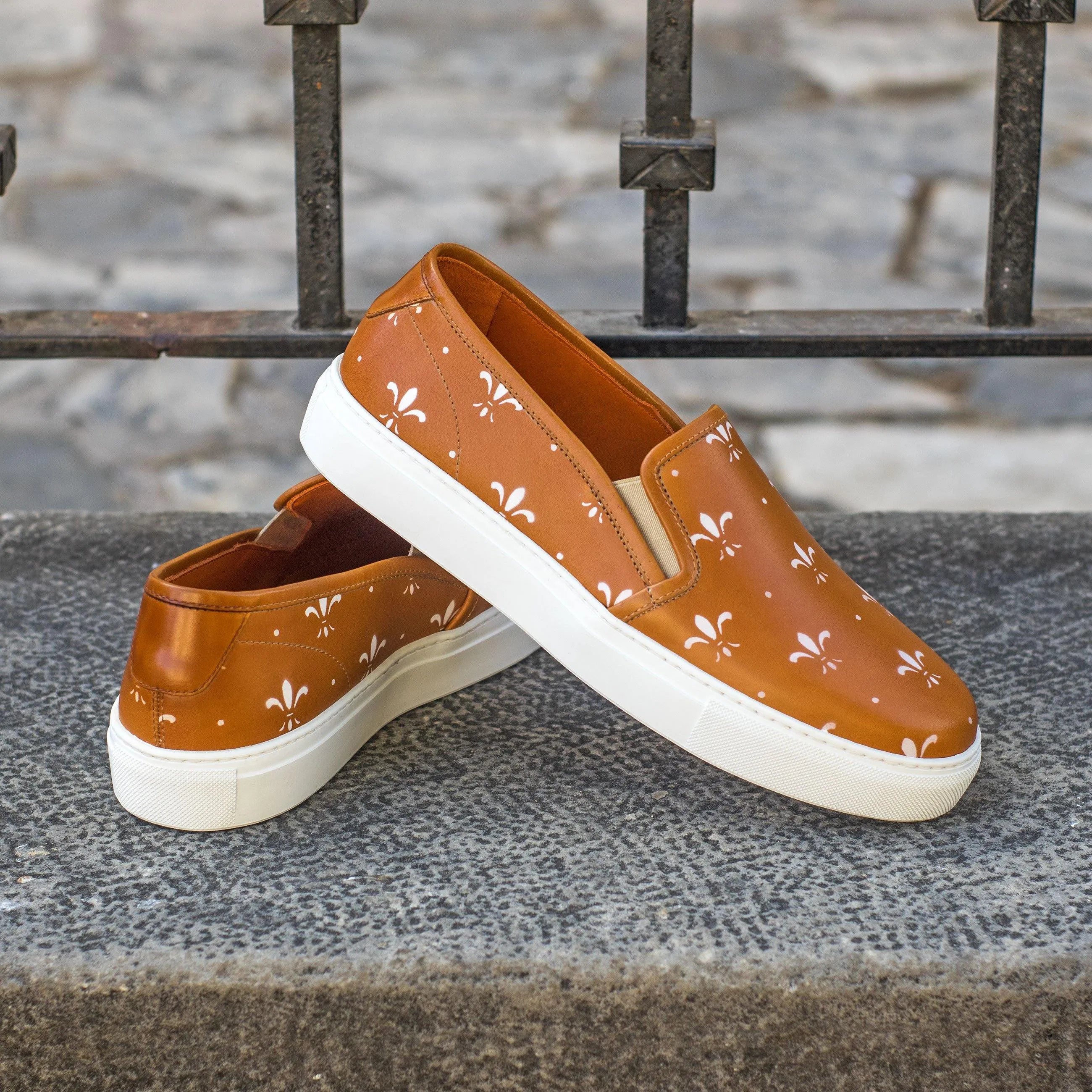Brown leather Jina21 Womens Slipon Sneakers featuring a white fleur-de-lis pattern