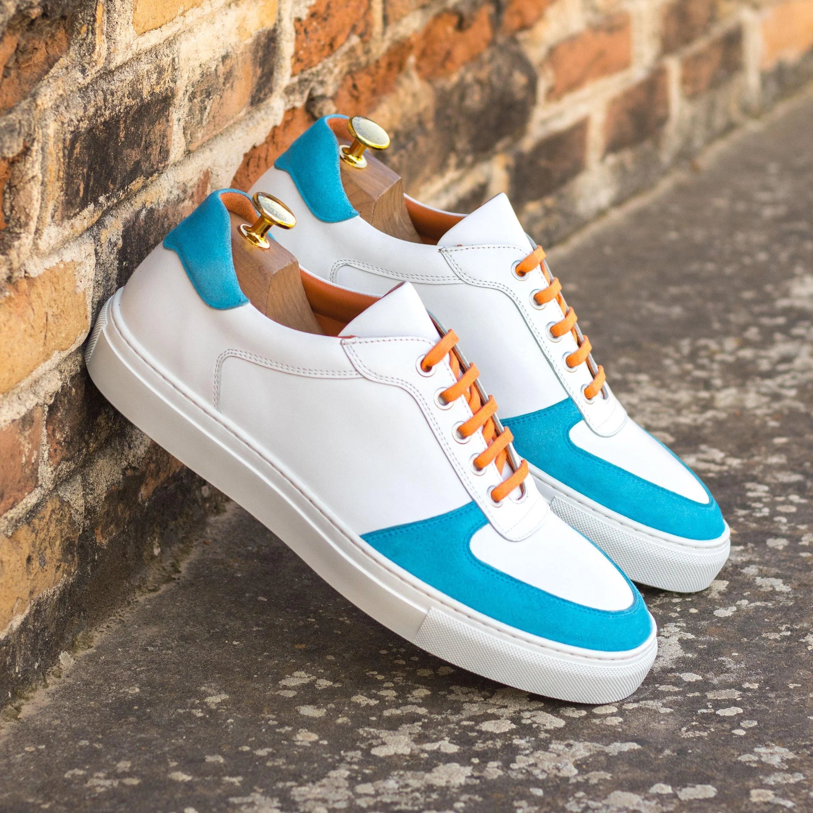 White and turquoise Junos Low Top Sneakers featuring vibrant orange laces