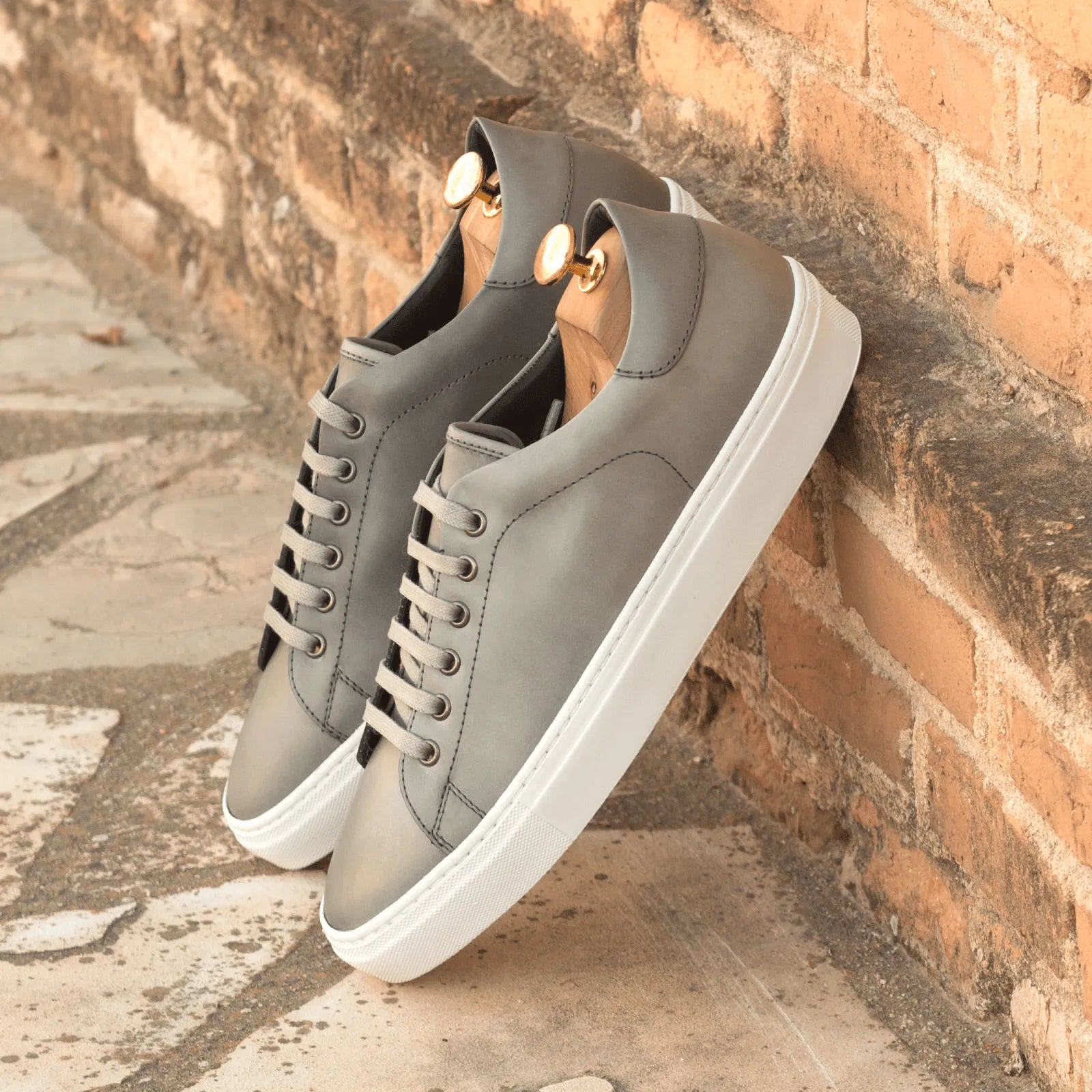 Gray leather sneakers featuring the Nicholas Trainer Sneaker style with cupsole design