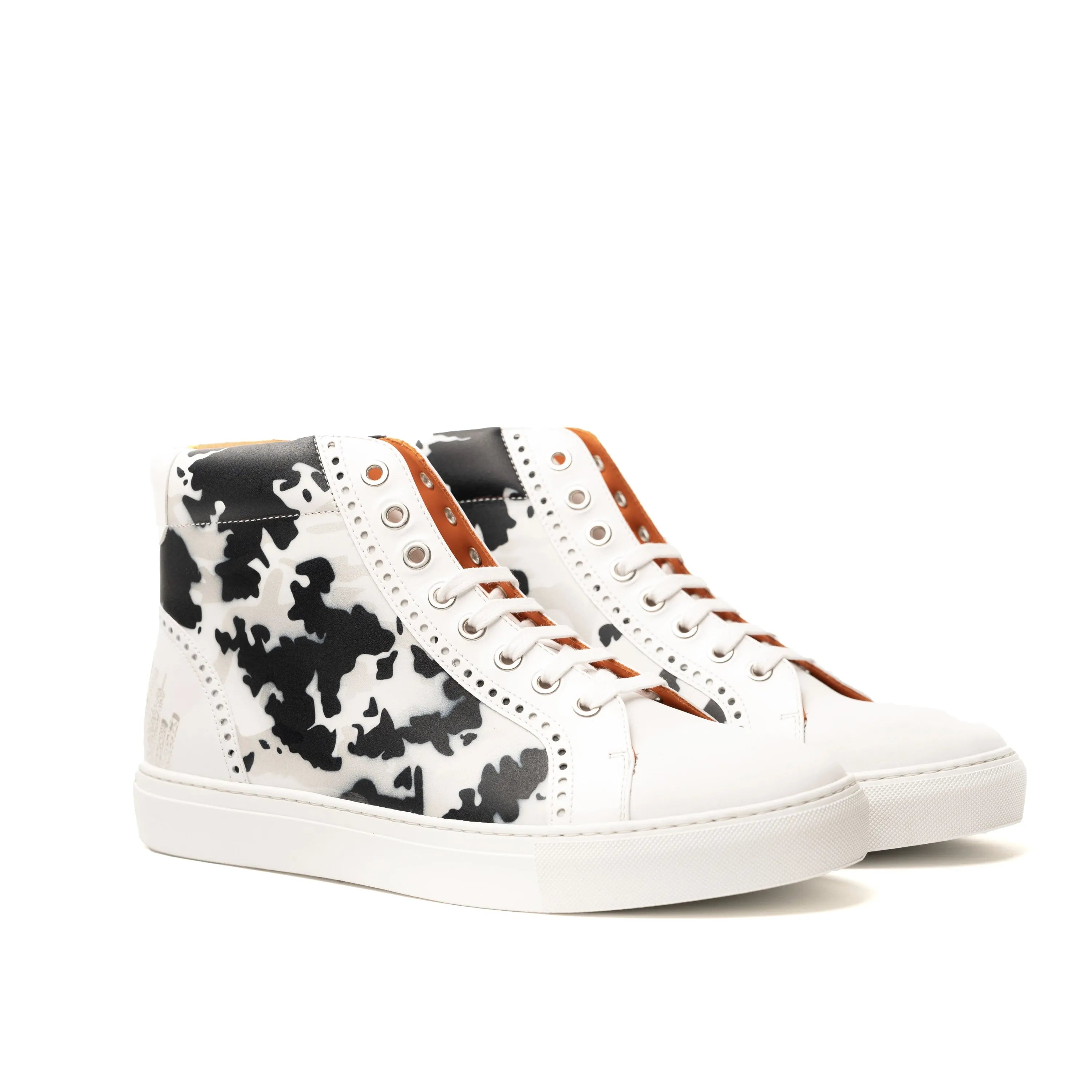White high-top NYC High Kicks Sneakers featuring a stylish black cow print design
