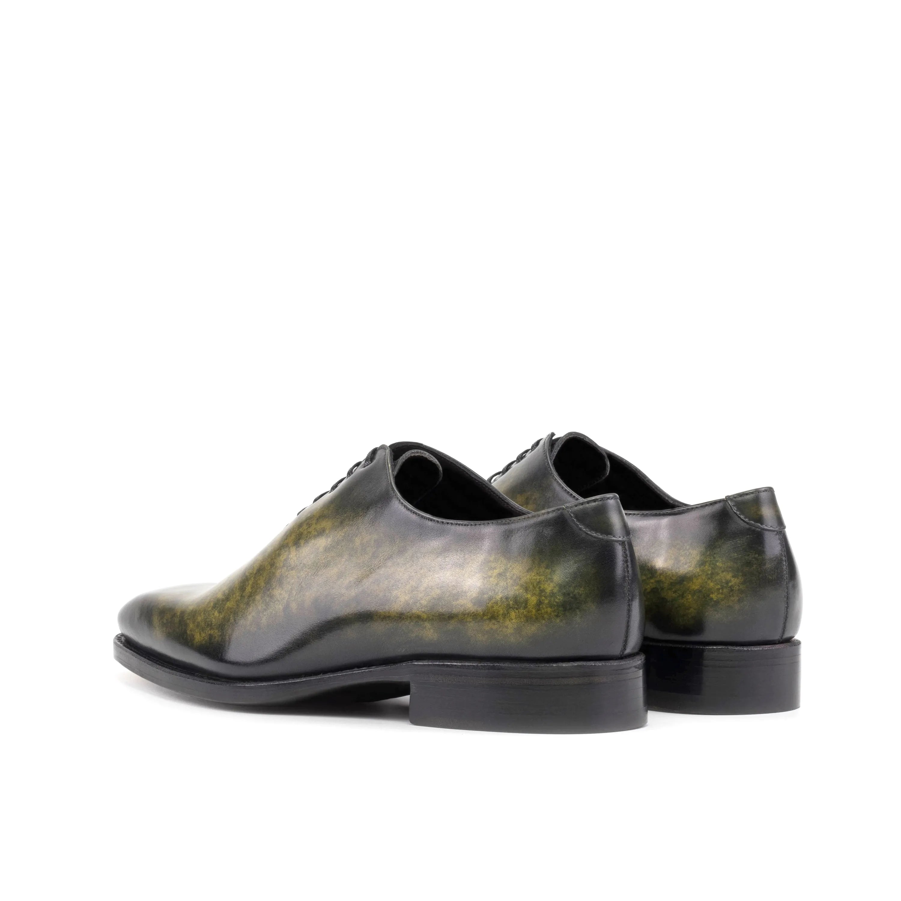 Pair of green leather Saturne Patina Wholecut shoes showcasing elegant craftsmanship