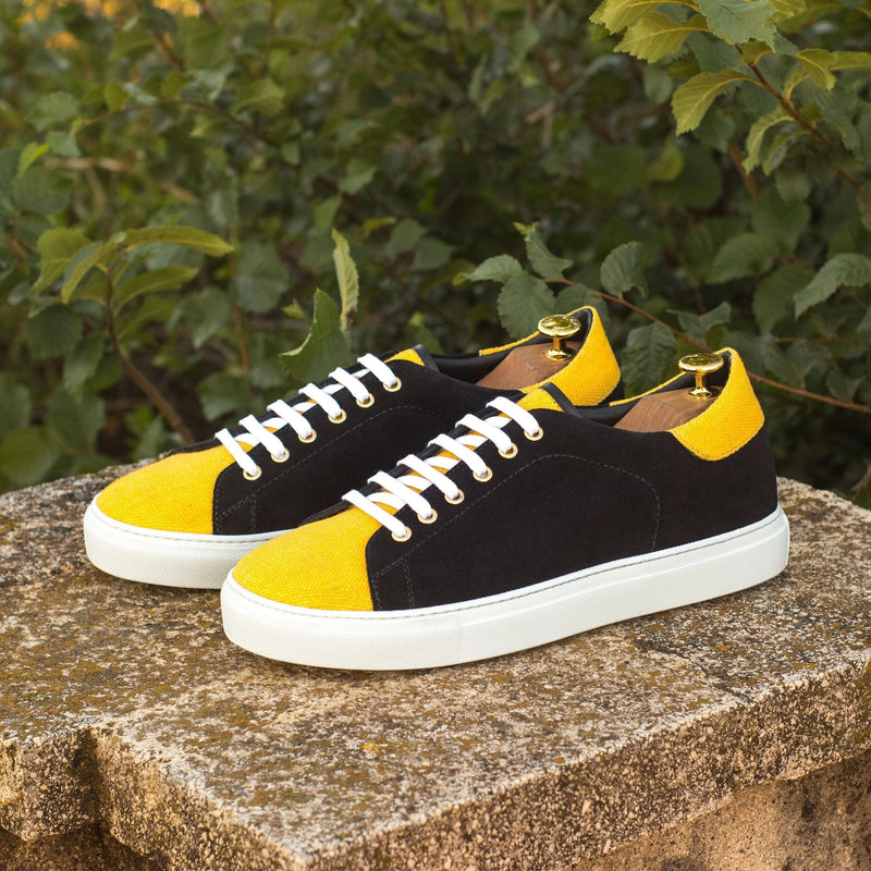 Black and yellow Travis Trainer Sneakers II with white laces displayed for stylish footwear