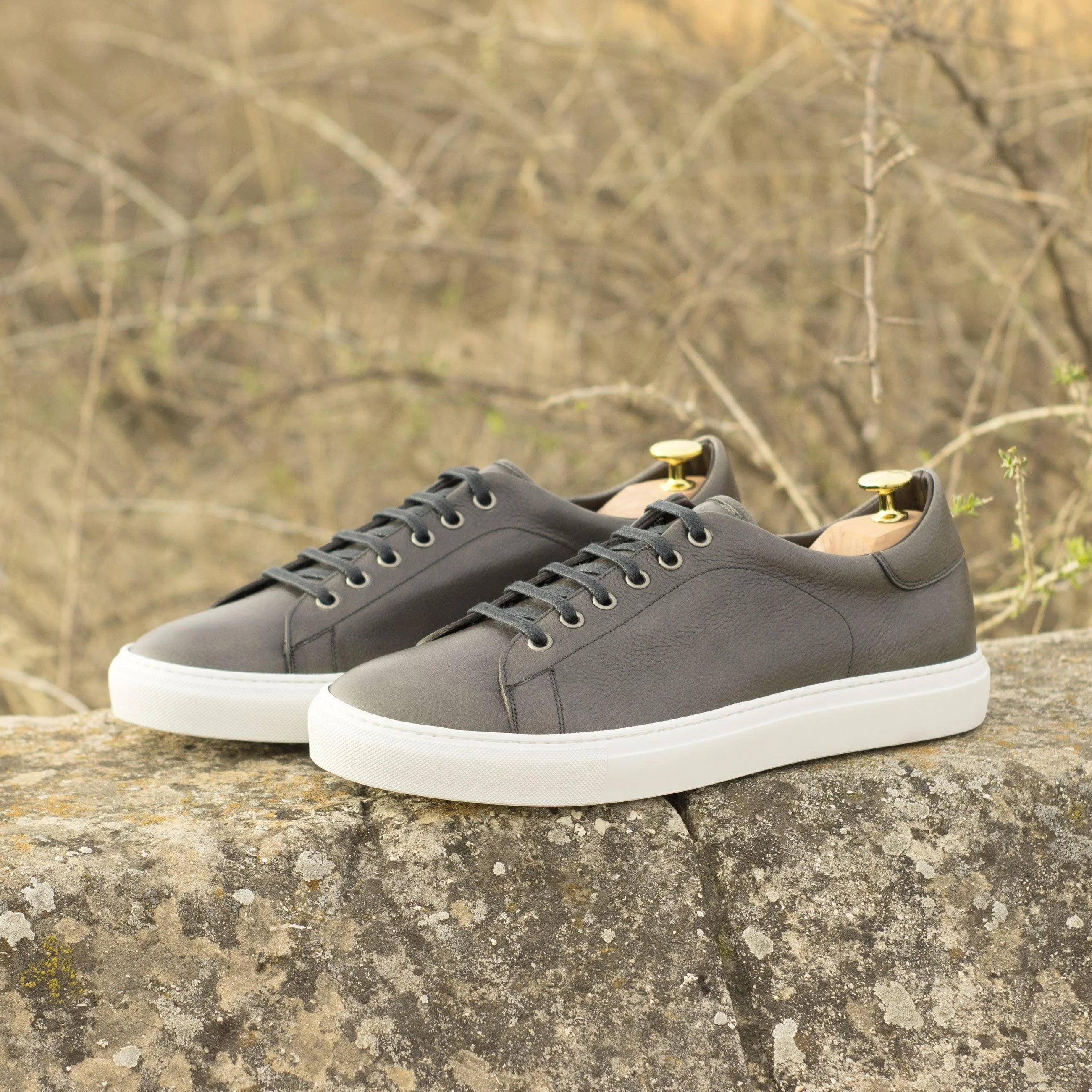 Gray leather Tuesday Trainer Sneakers featuring stylish white soles for modern footwear